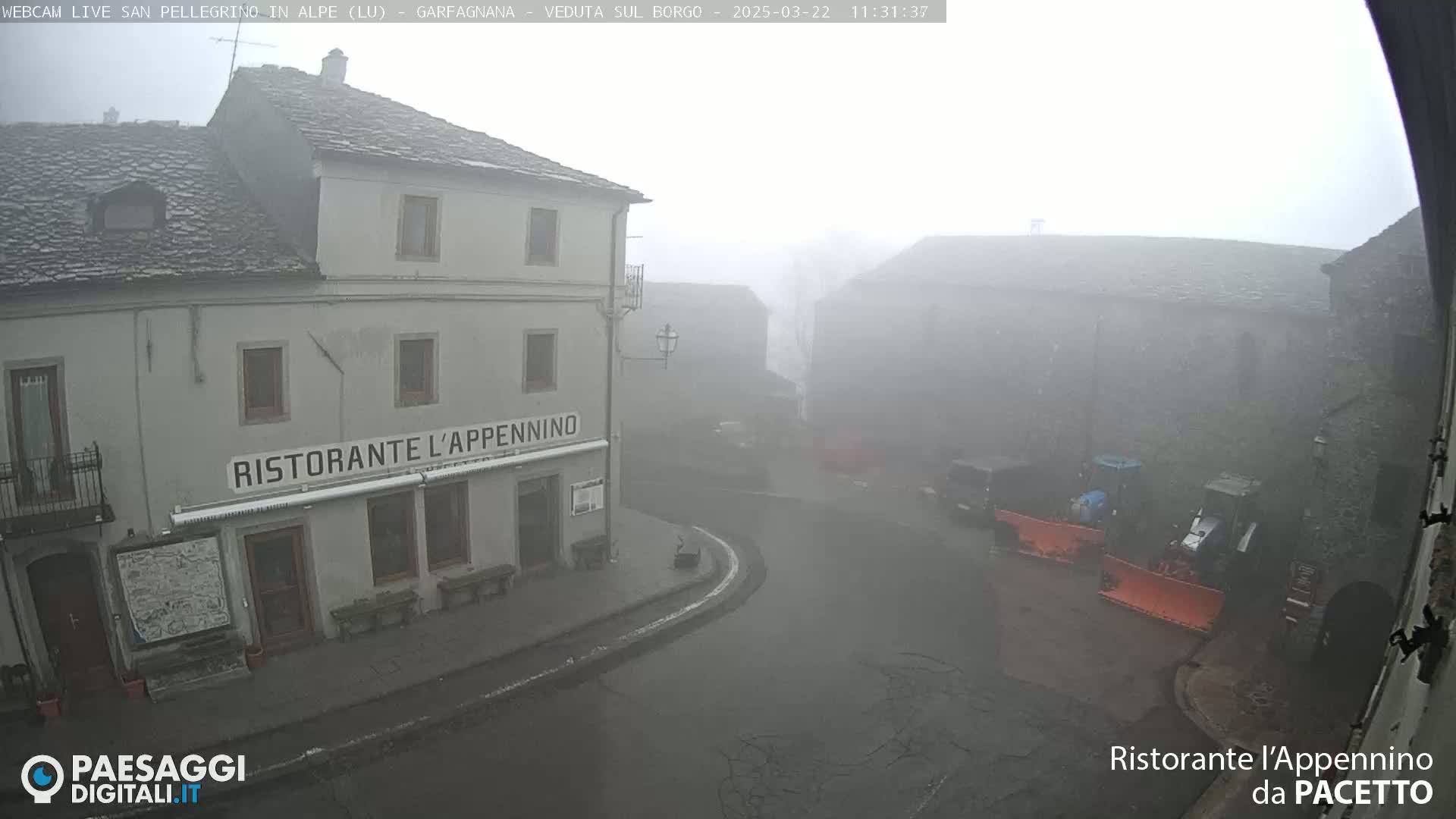 A foggy village square is seen, with a restaurant called "Ristorante l'Appennino" visible near the corner, and snowplows parked nearby.