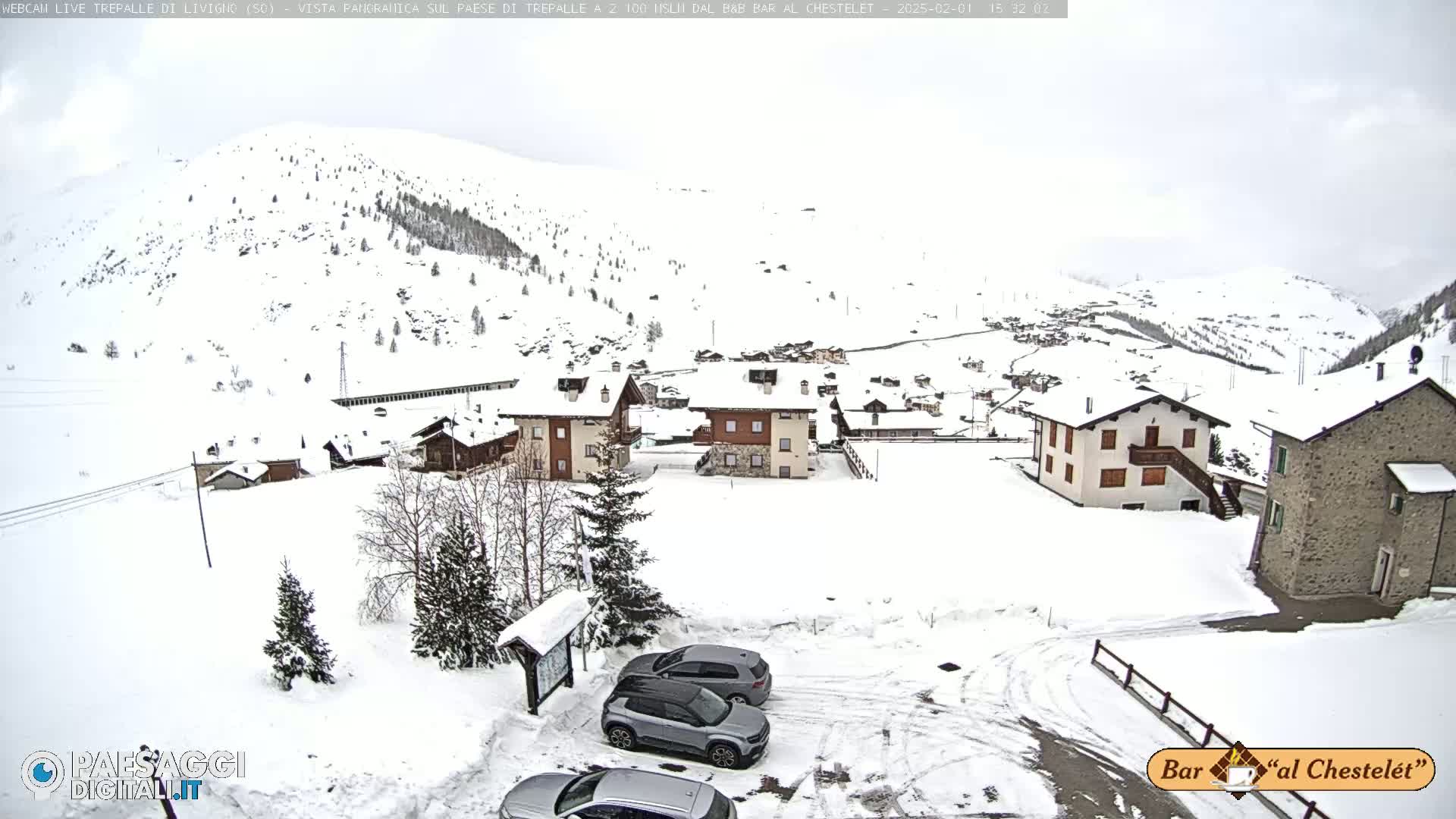 A snow-covered village nestled in a mountainous region under an overcast sky.