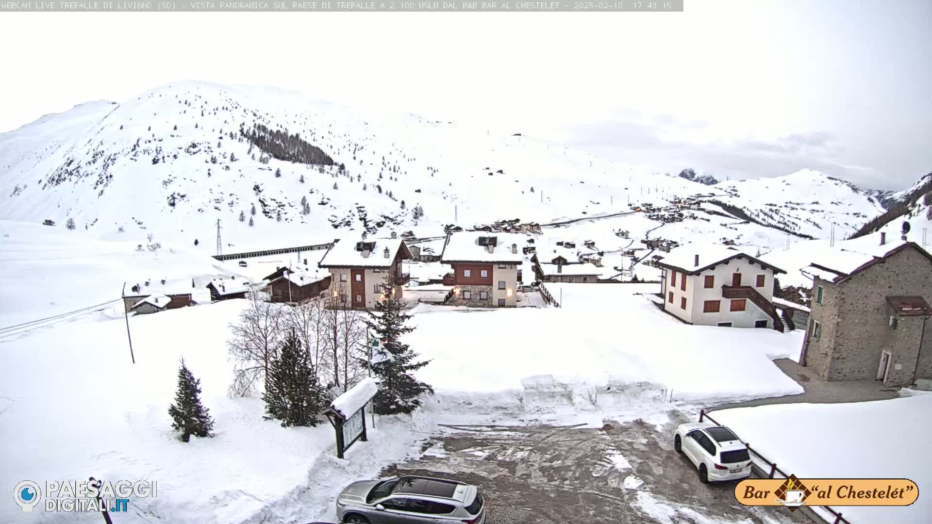 A snow-covered village nestled in a mountainous region under an overcast sky.