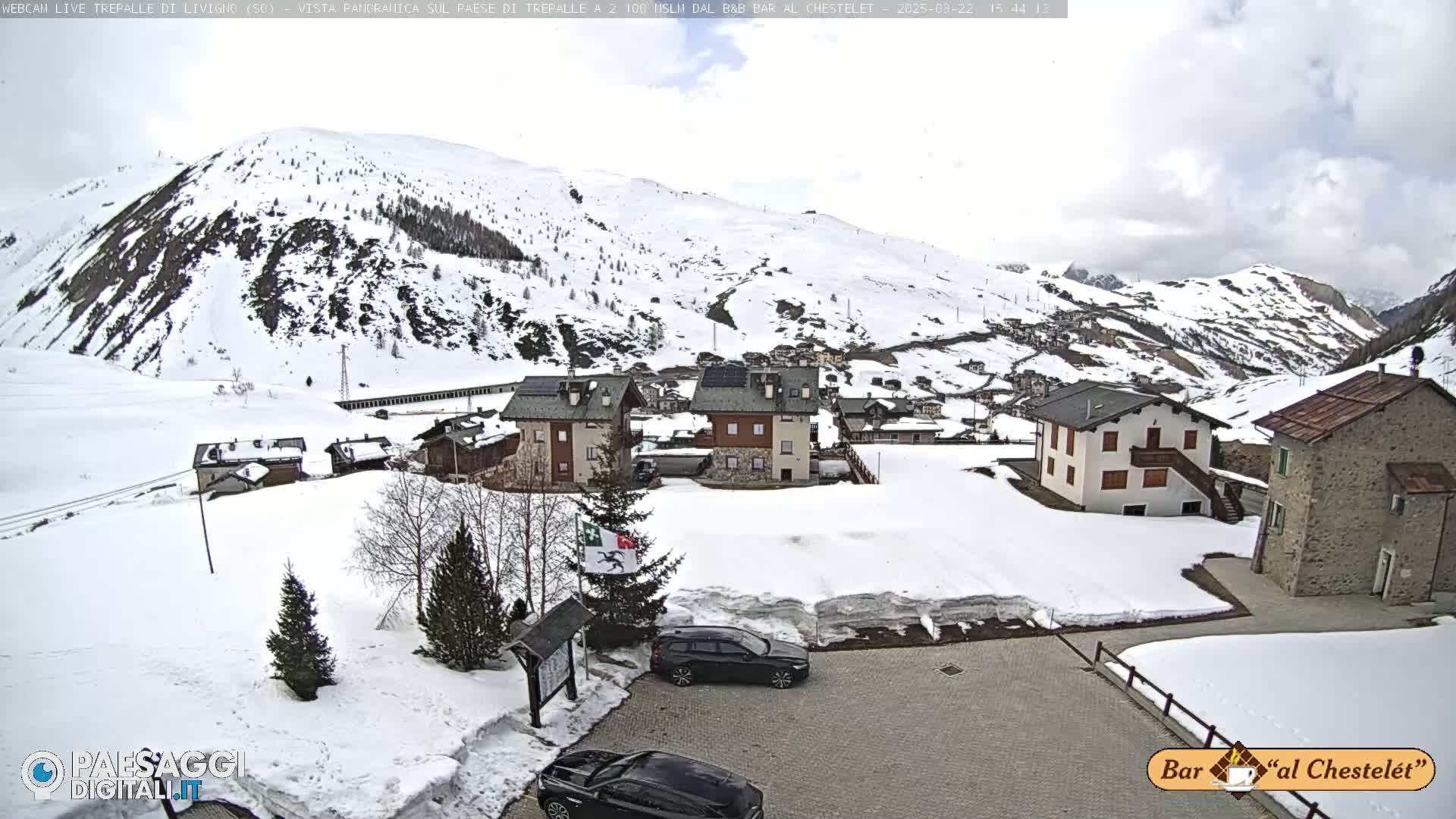 A snow-covered mountain village is seen under a cloudy sky.