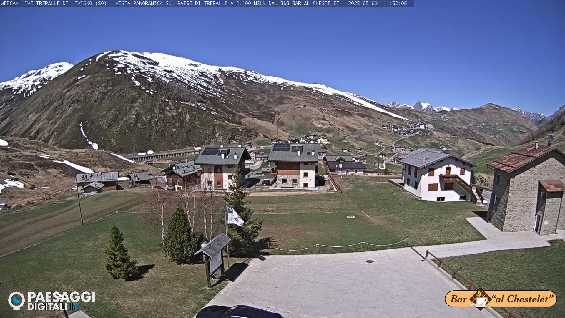 A sunny mountain village nestled beneath snow-capped peaks.