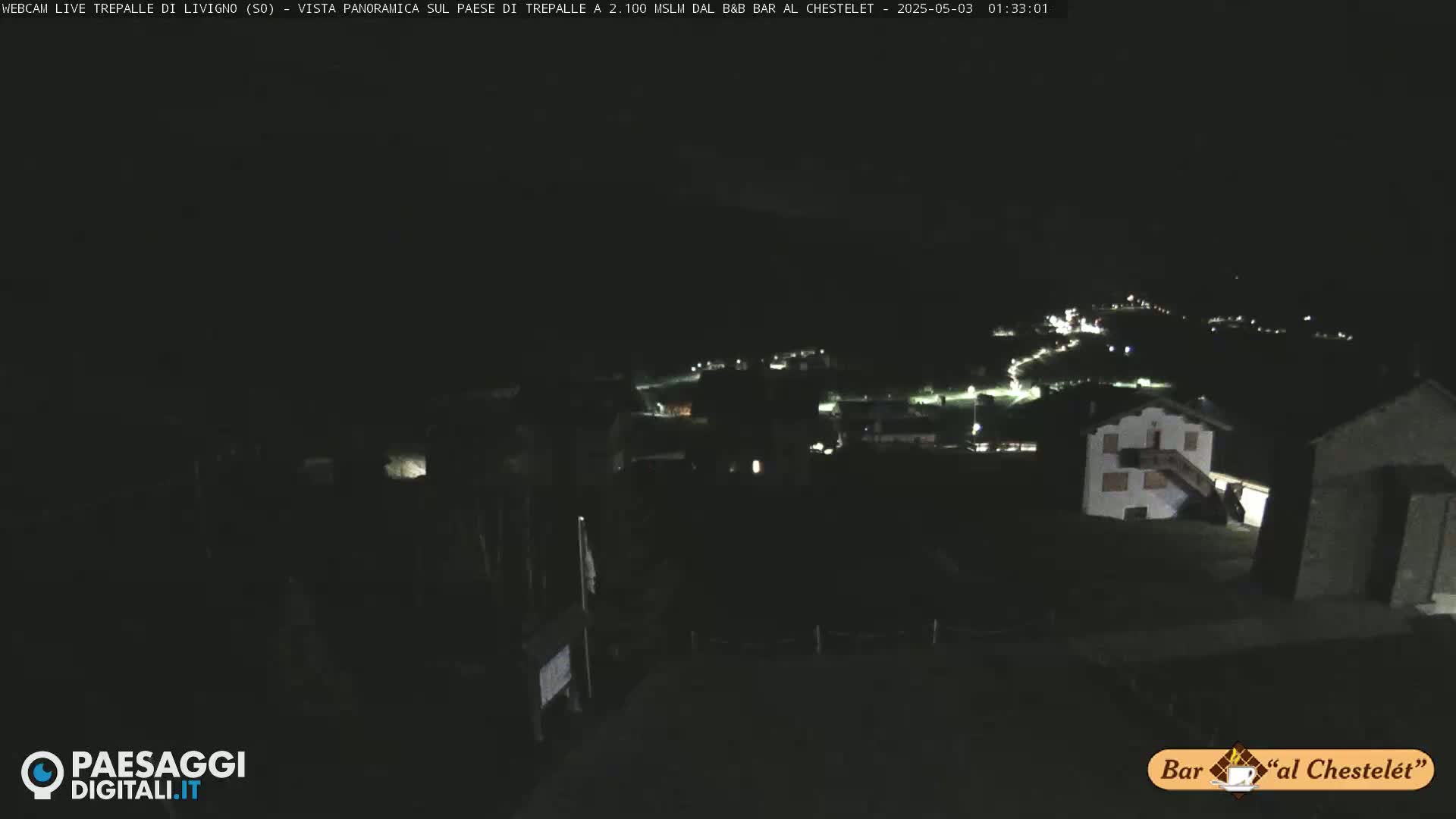A nighttime, high-angle view of a small village illuminated by scattered lights.
