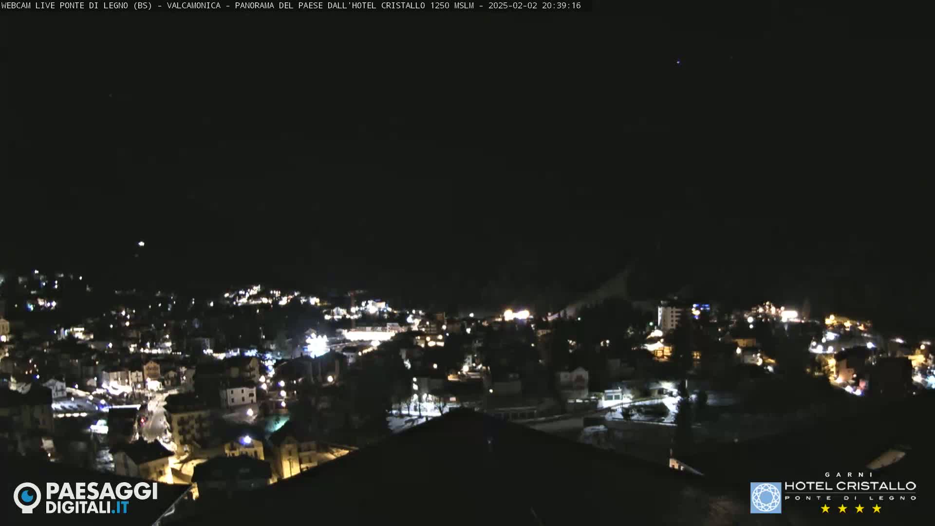 A nighttime, high-angle view of a town illuminated by lights under a clear, dark sky.