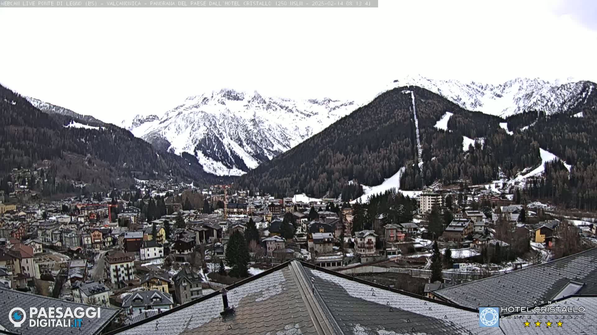 A snow-dusted town nestled in a valley surrounded by snow-capped mountains.