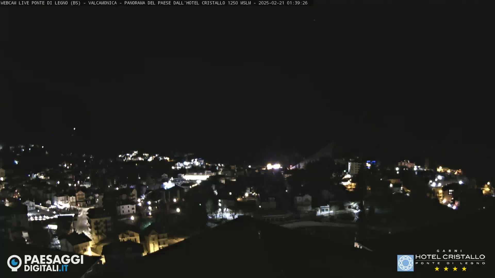 A nighttime, long shot of a town illuminated by streetlights under a clear, dark sky.