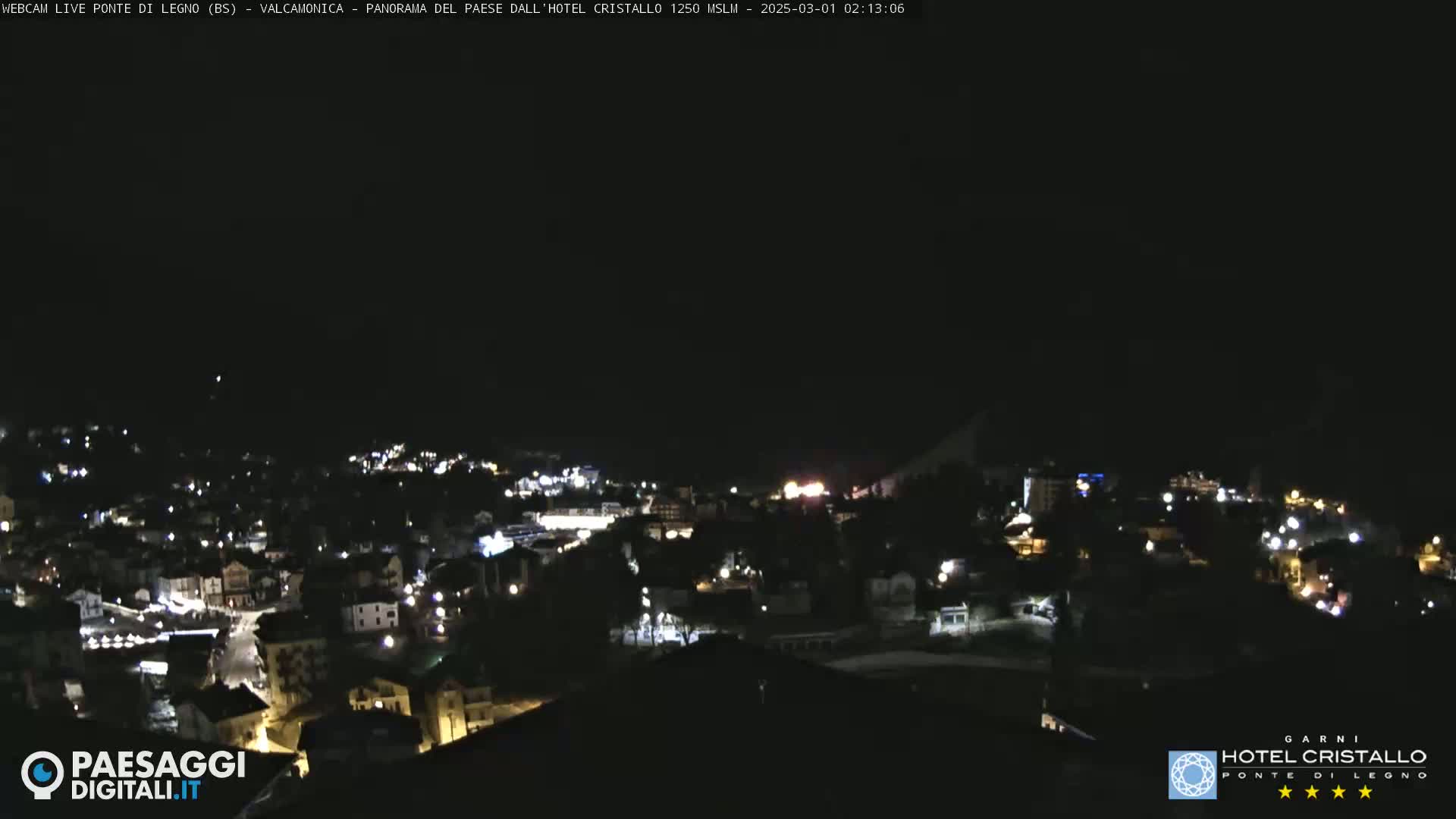 A nighttime, aerial view of a small town illuminated by scattered lights under a clear, dark sky.