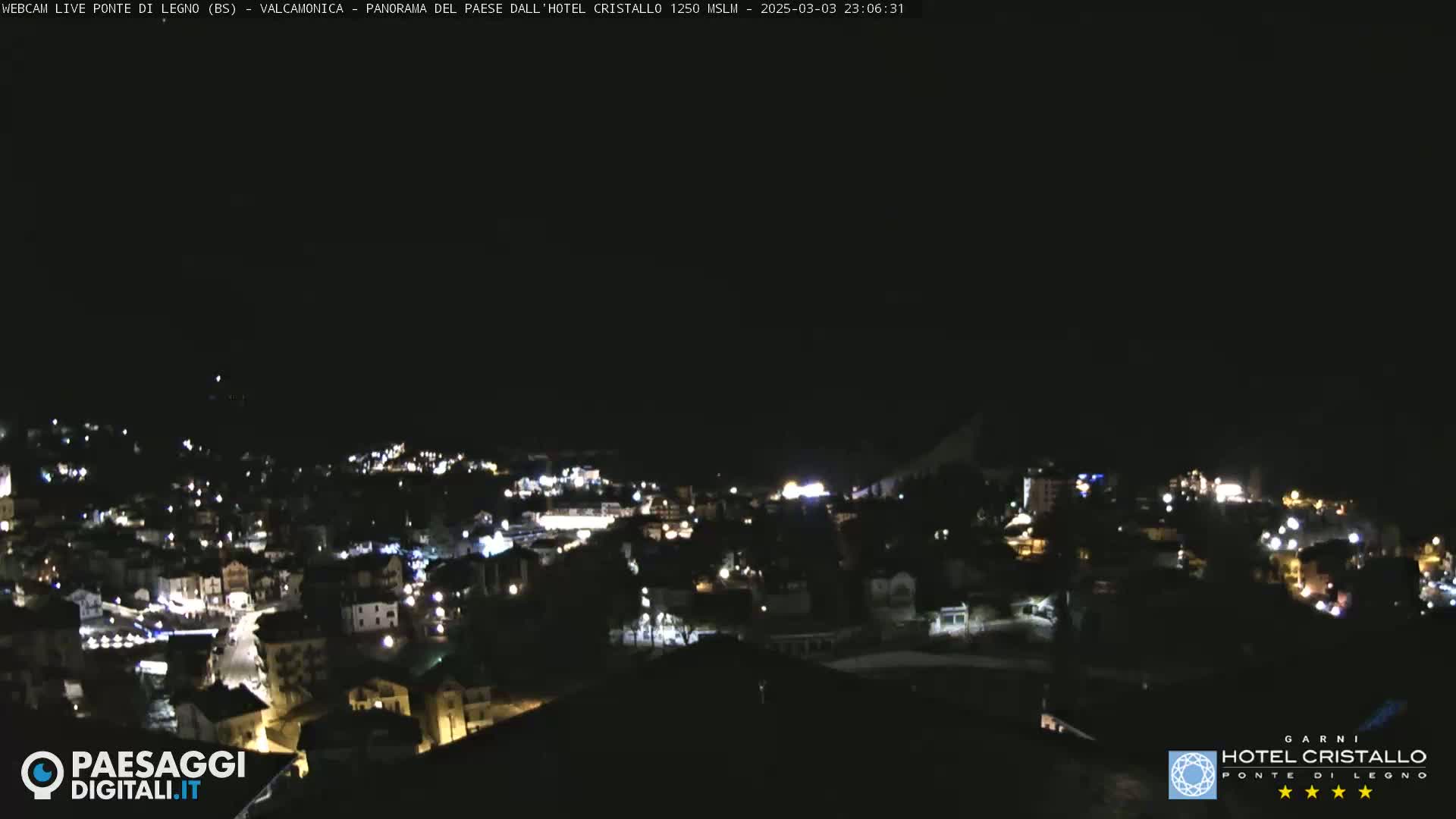 A nighttime, long shot of a town illuminated by streetlights under a clear, dark sky.