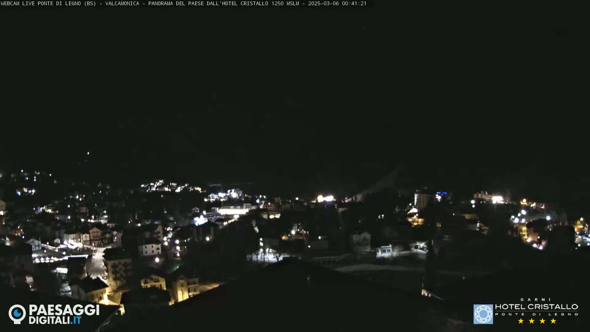 A nighttime, high-angle view of a town illuminated by streetlights under a clear, dark sky.