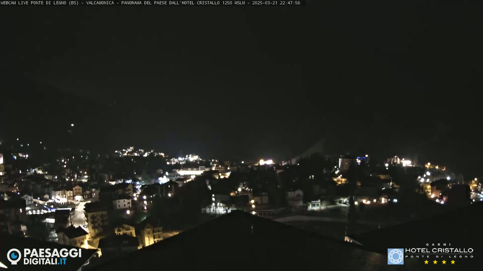 A nighttime, long shot of a town illuminated by streetlights under a clear, dark sky.