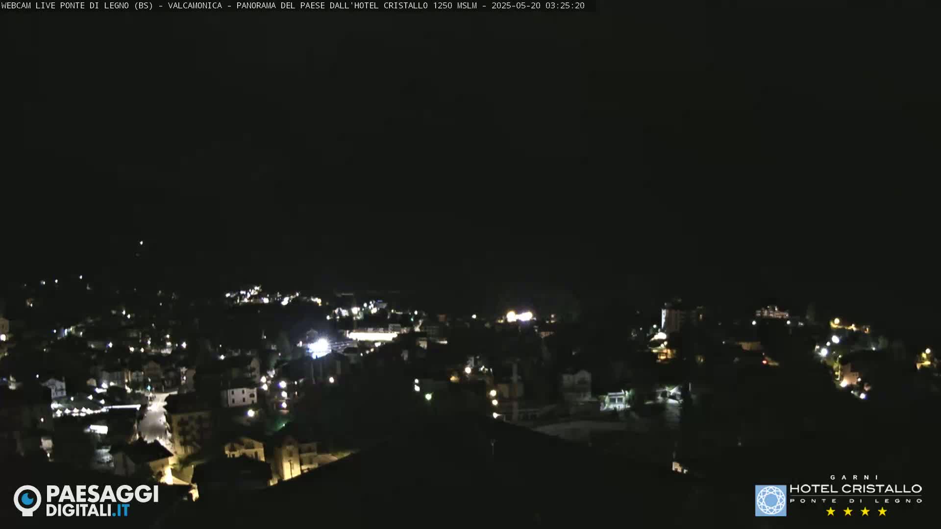 A nighttime, aerial view of a town illuminated by scattered lights under a clear, dark sky.