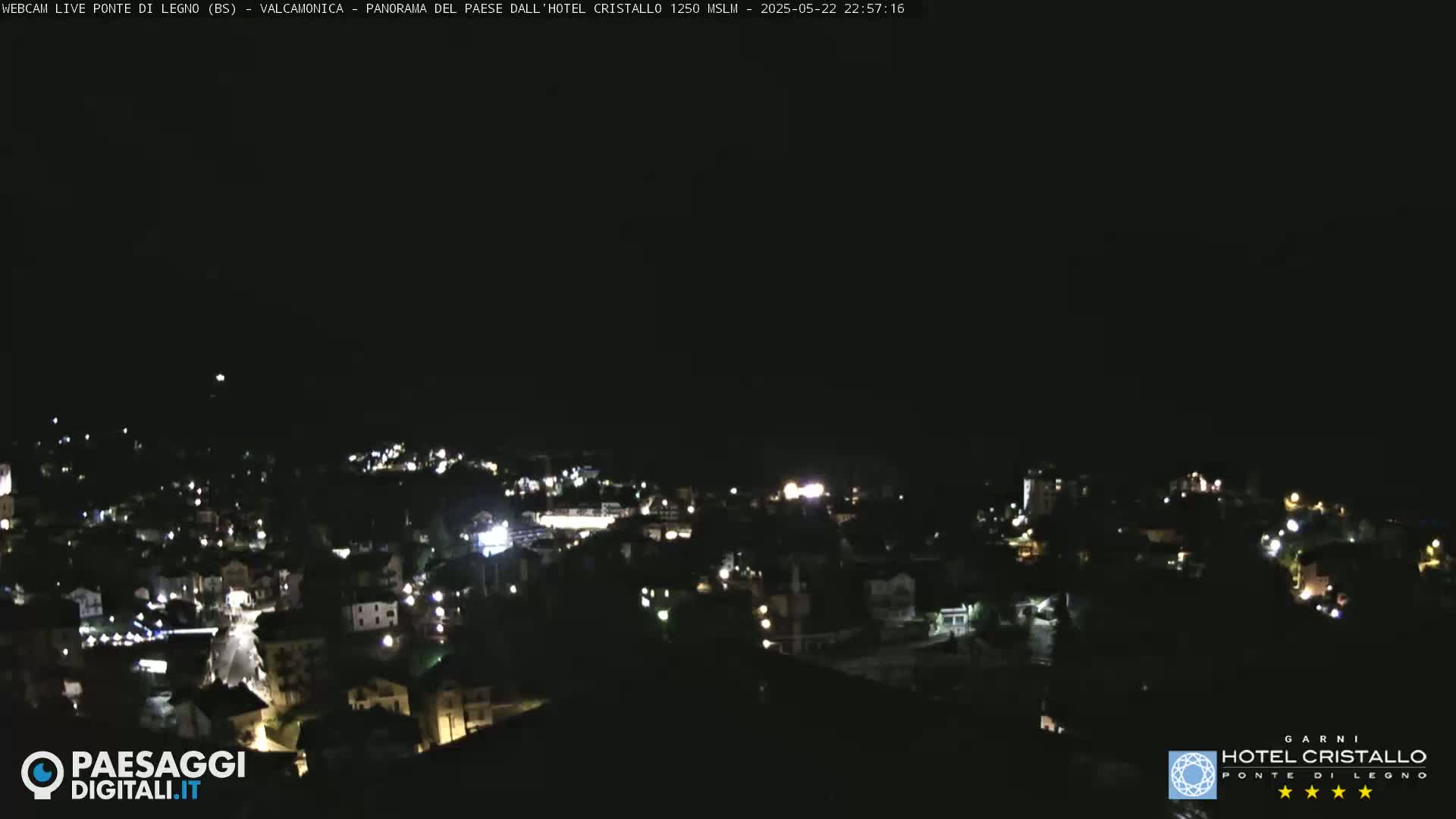 A nighttime, aerial view of a town illuminated by scattered lights under a clear, dark sky.