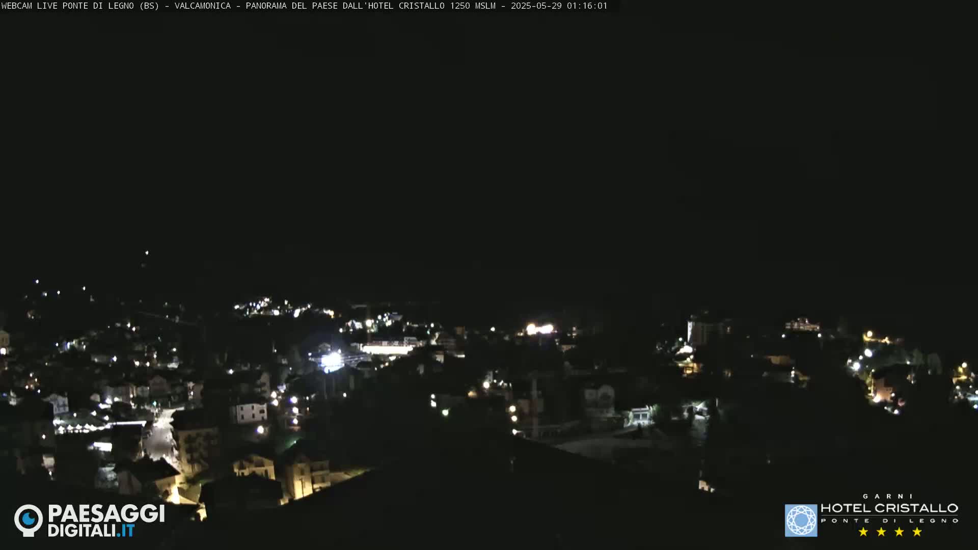 A nighttime, high-angle view of a small town illuminated by scattered lights.
