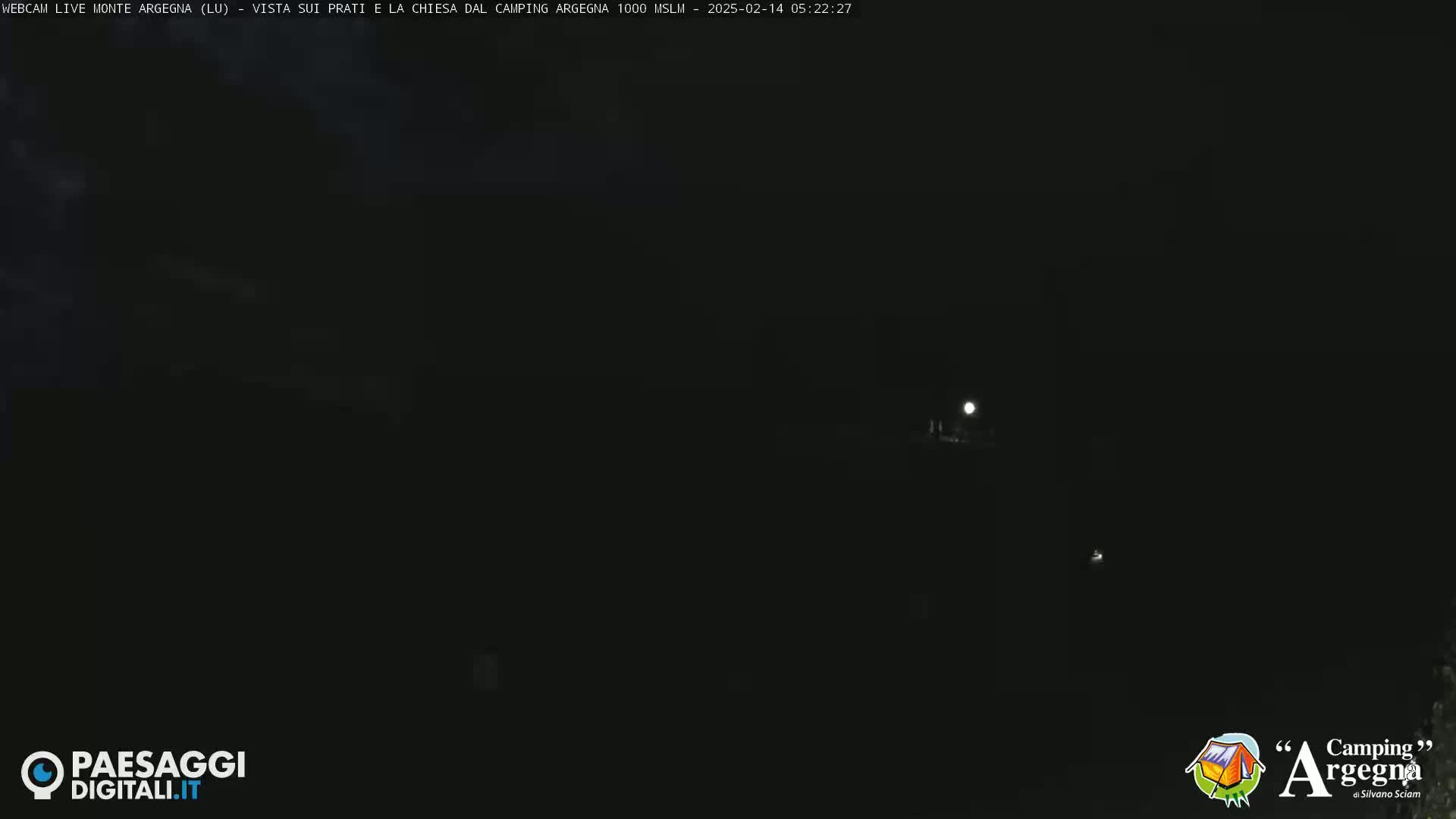A nighttime, dark outdoor scene with a dimly lit area in the distance and a bright moon visible in the sky.