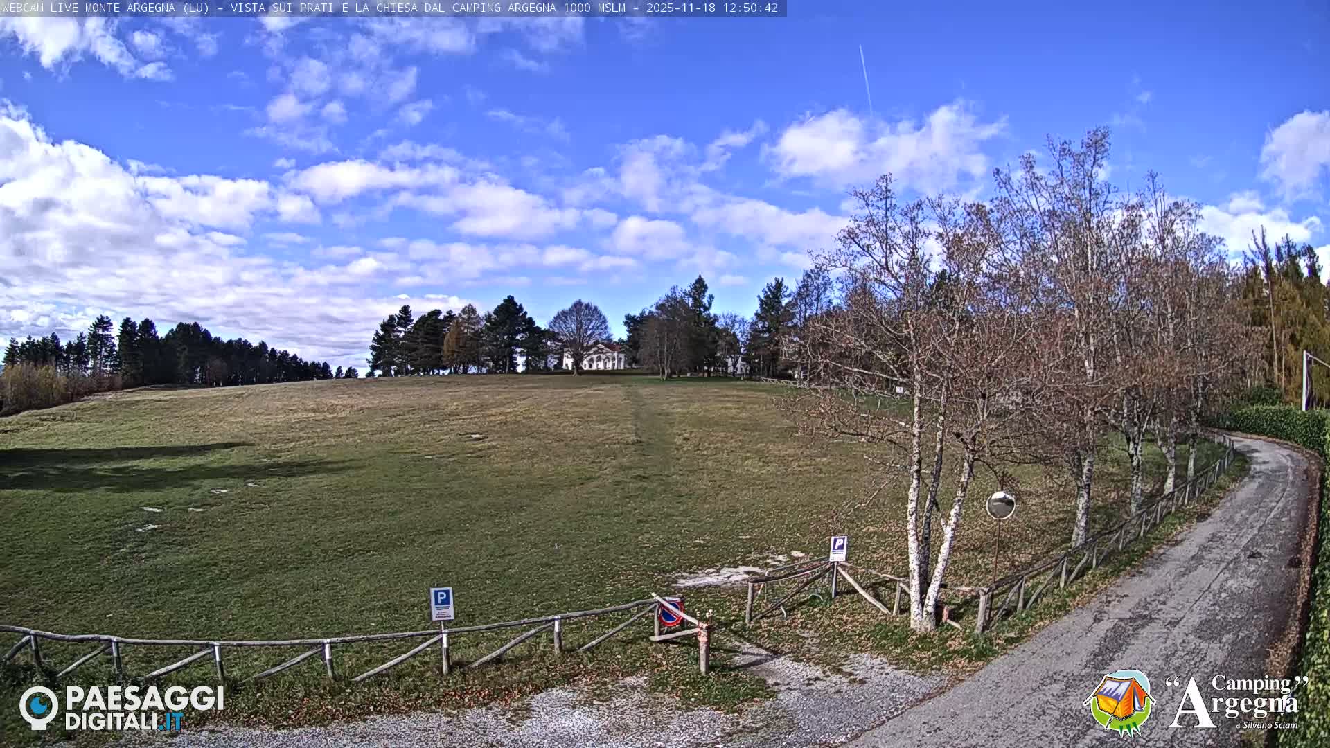 The image displays an extremely dark outdoor nighttime scene, with a few faint lights scattered in the distance under clear conditions.