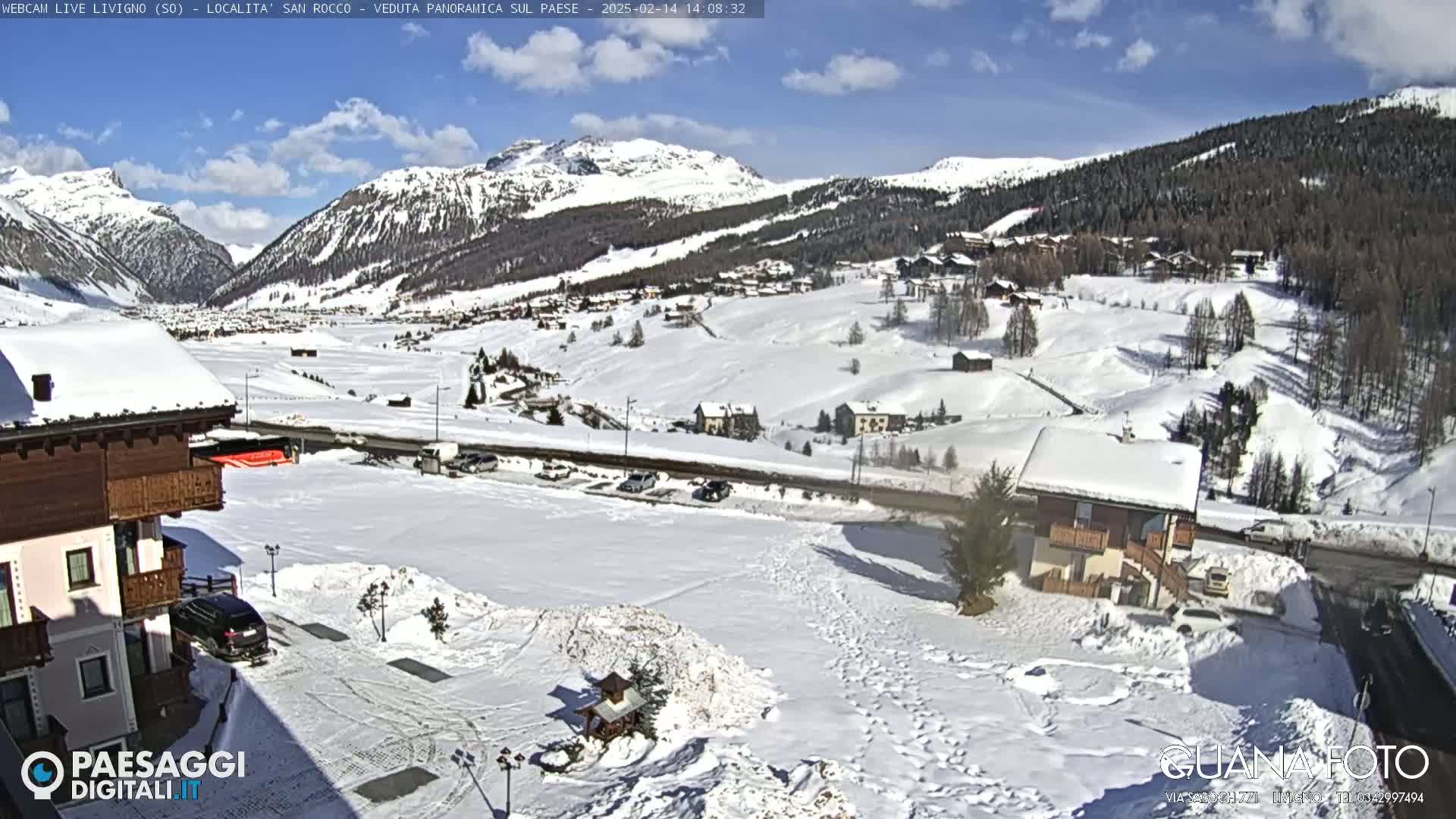 A snow-covered mountain village under a partly sunny sky.
