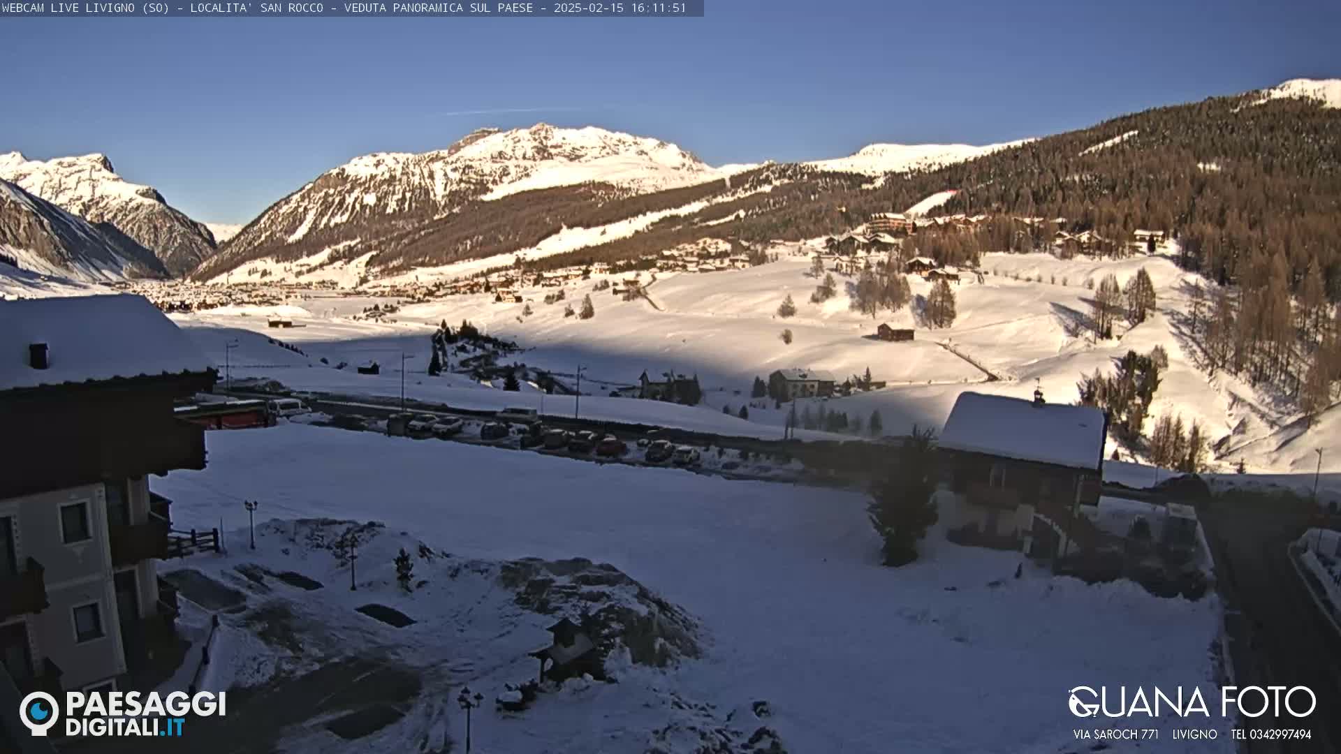 A snow-covered mountain village nestled in a valley under a clear blue sky.