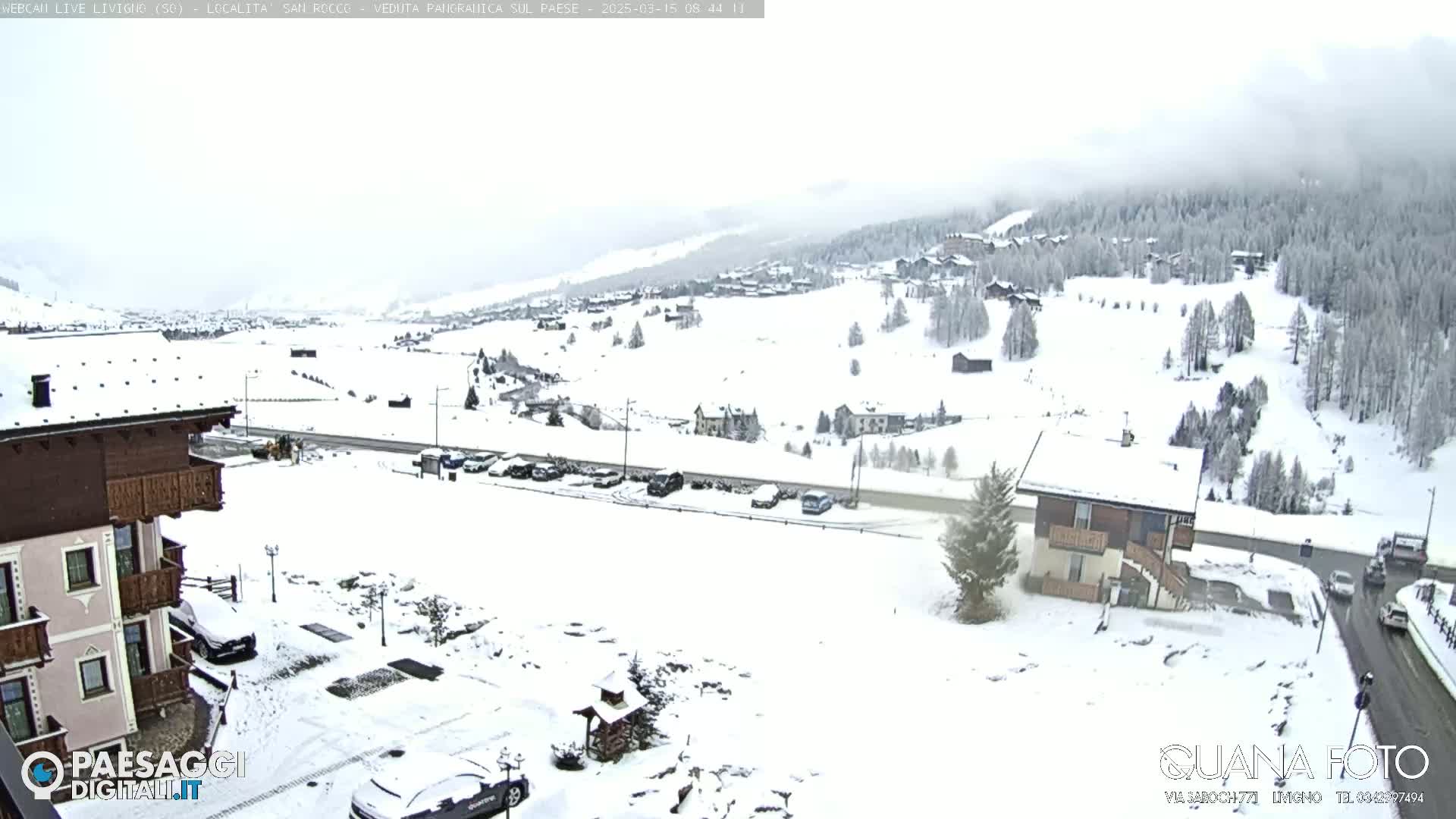 A snow-covered mountain village scene is visible under an overcast sky.