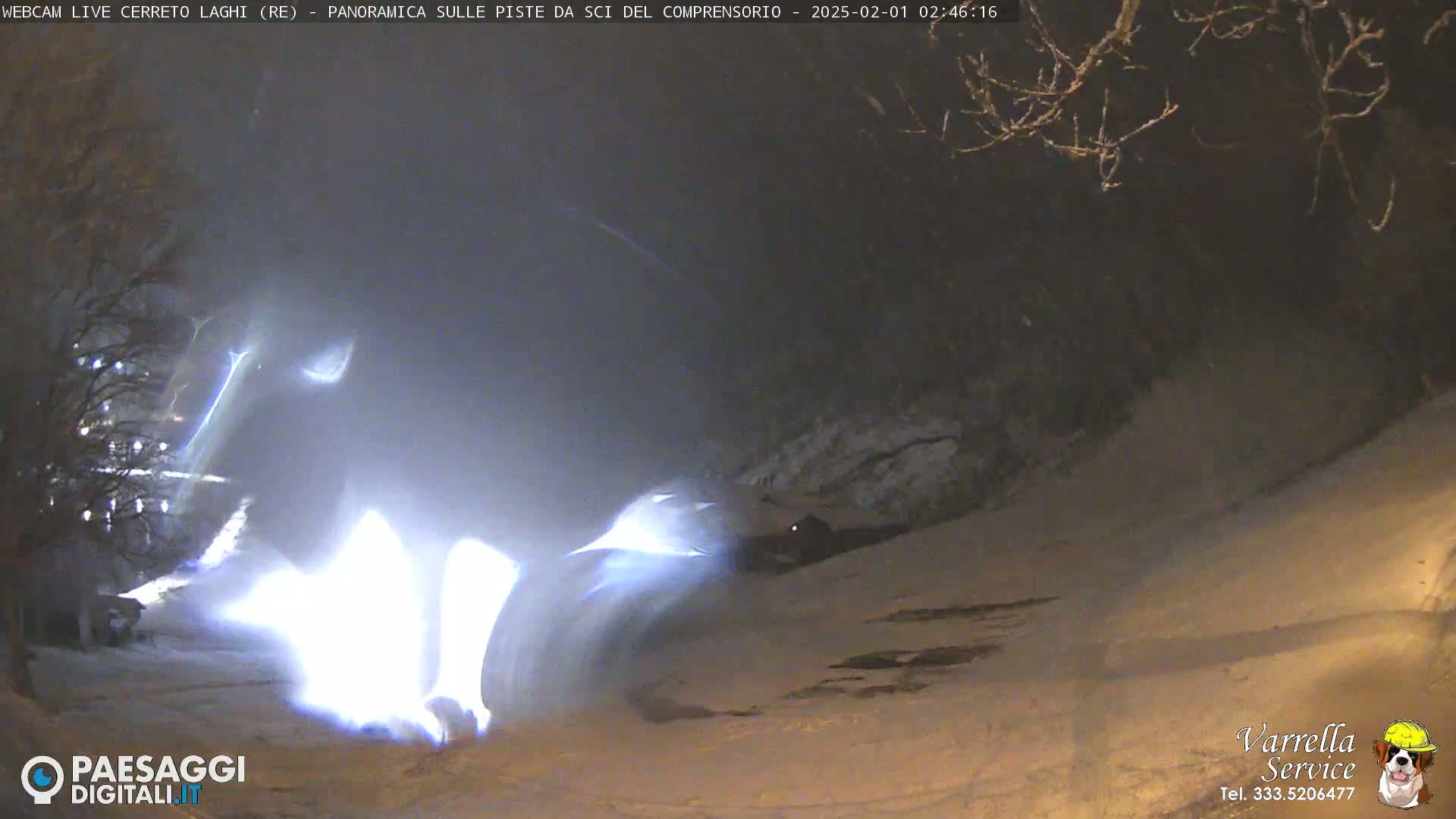 A bright light streaks across a snow-covered landscape at night.
