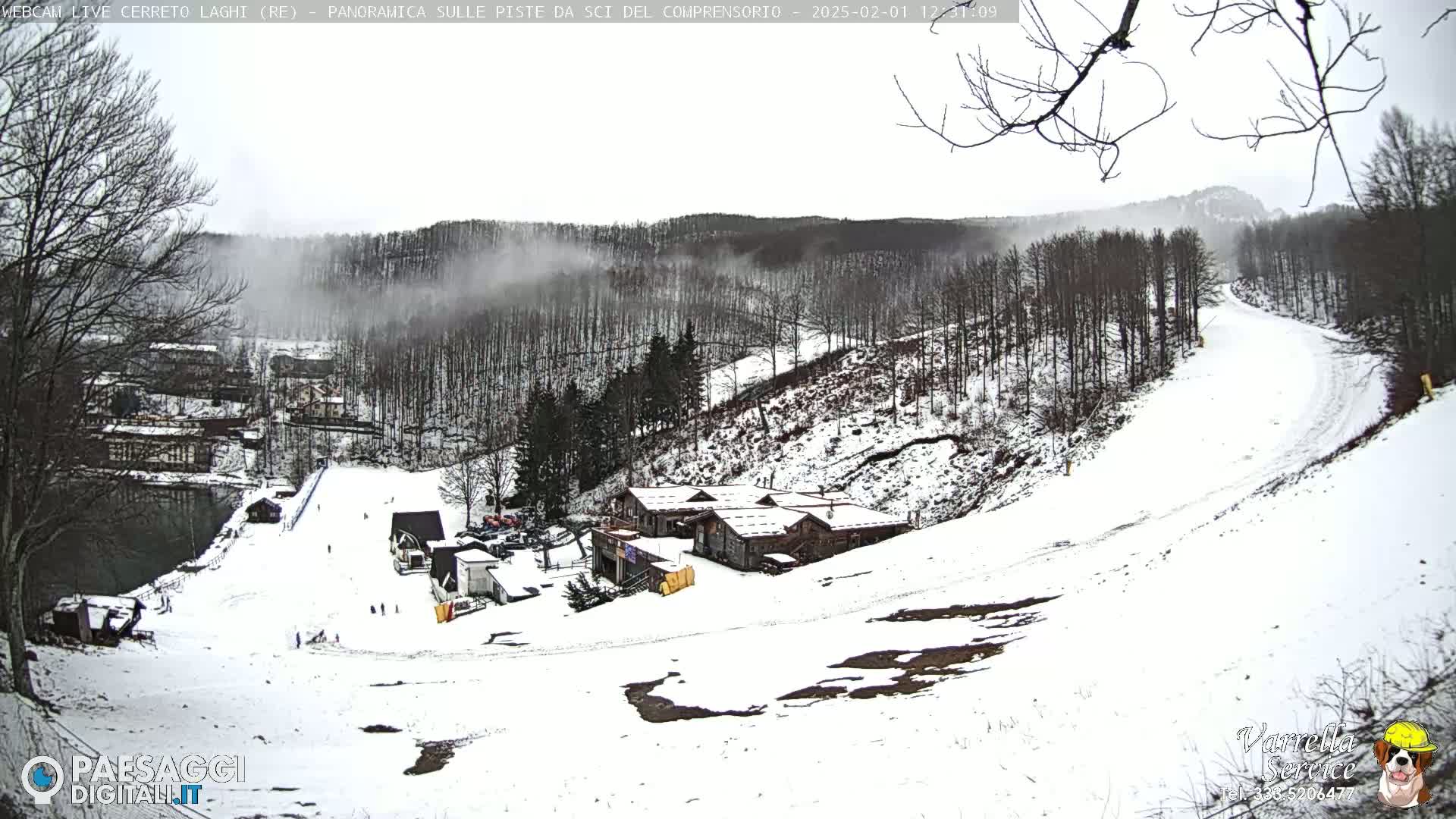 A snow-covered ski slope and resort are visible, with a light snowfall and fog in the background.