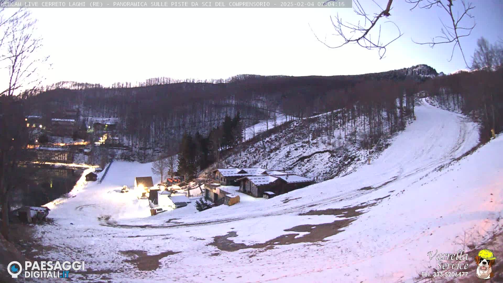A snow-covered ski slope and resort are visible at twilight, with a mountainside forest in the background.