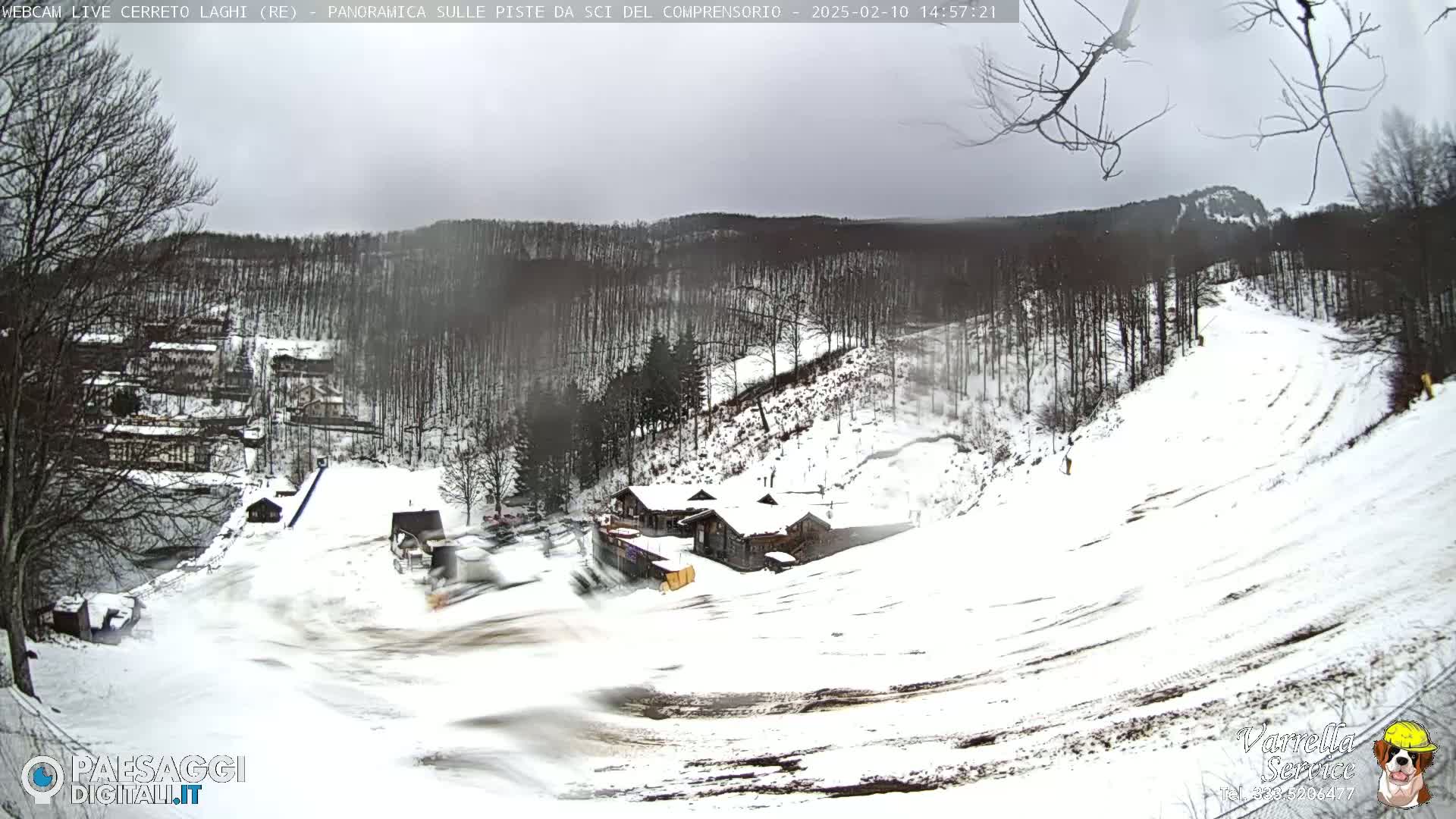 A snow-covered ski slope with a building at the bottom, under an overcast sky.