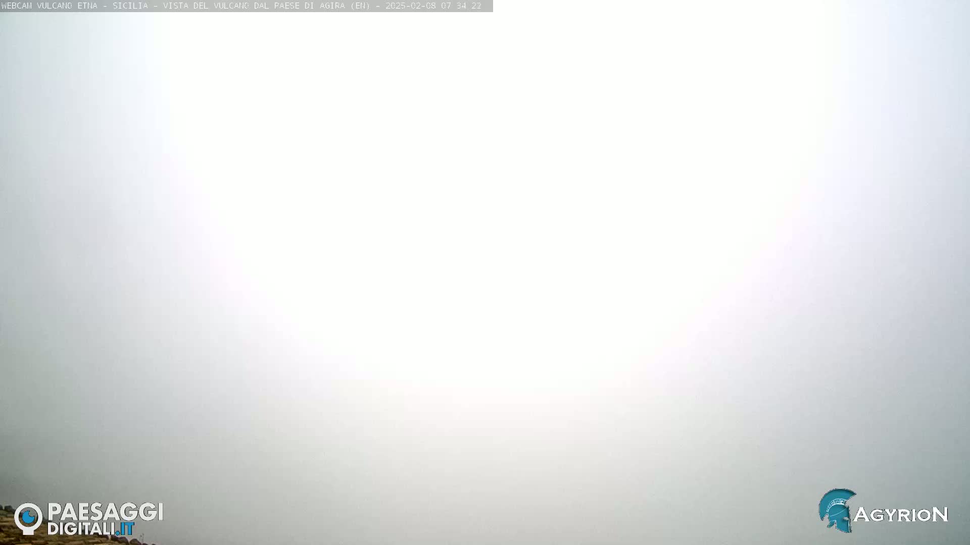 A thick, white fog obscures the view of the landscape.