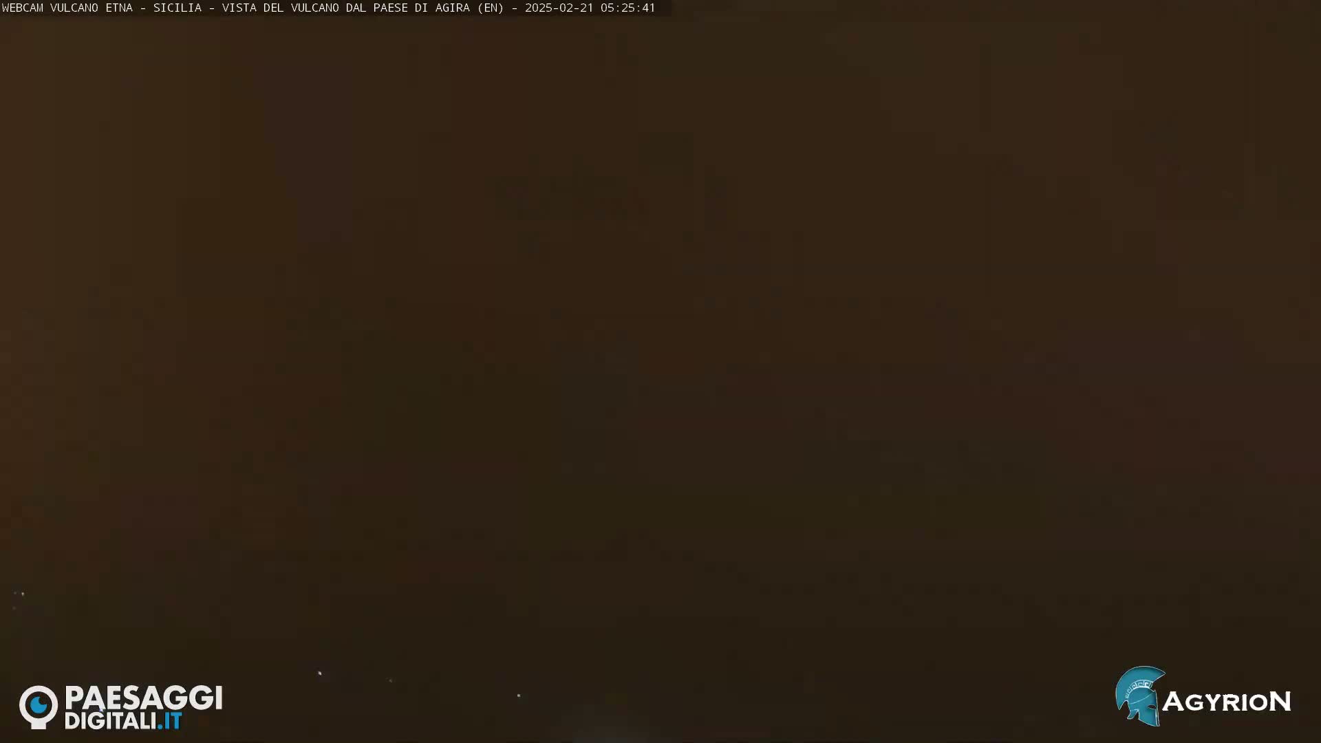 A dark, nighttime image shows a mostly featureless, dark brown landscape.