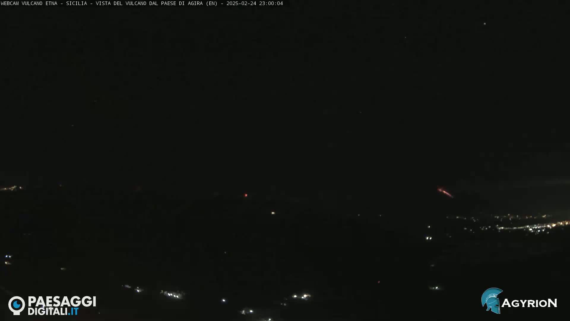 A nighttime long shot shows a dark landscape with a few distant lights and a reddish streak in the sky.