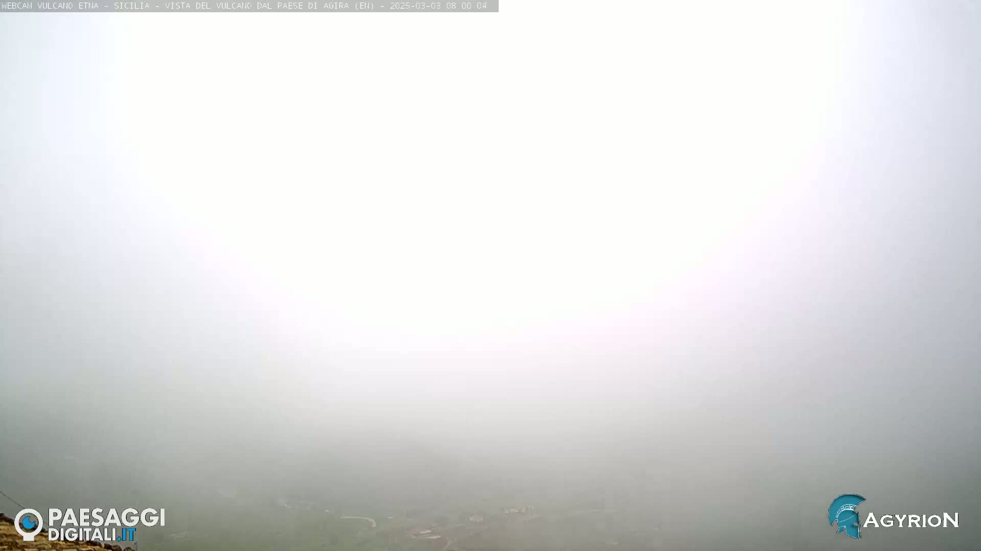 A thick fog obscures the view of a distant landscape.