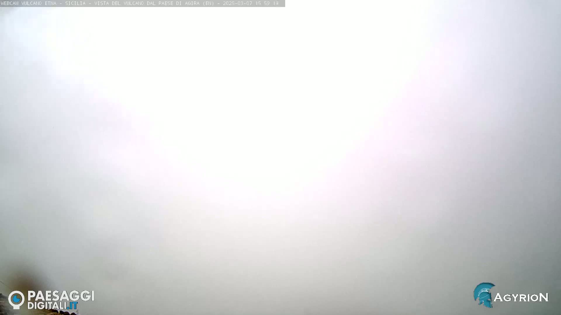 A very hazy, light-grey outdoor scene is visible.