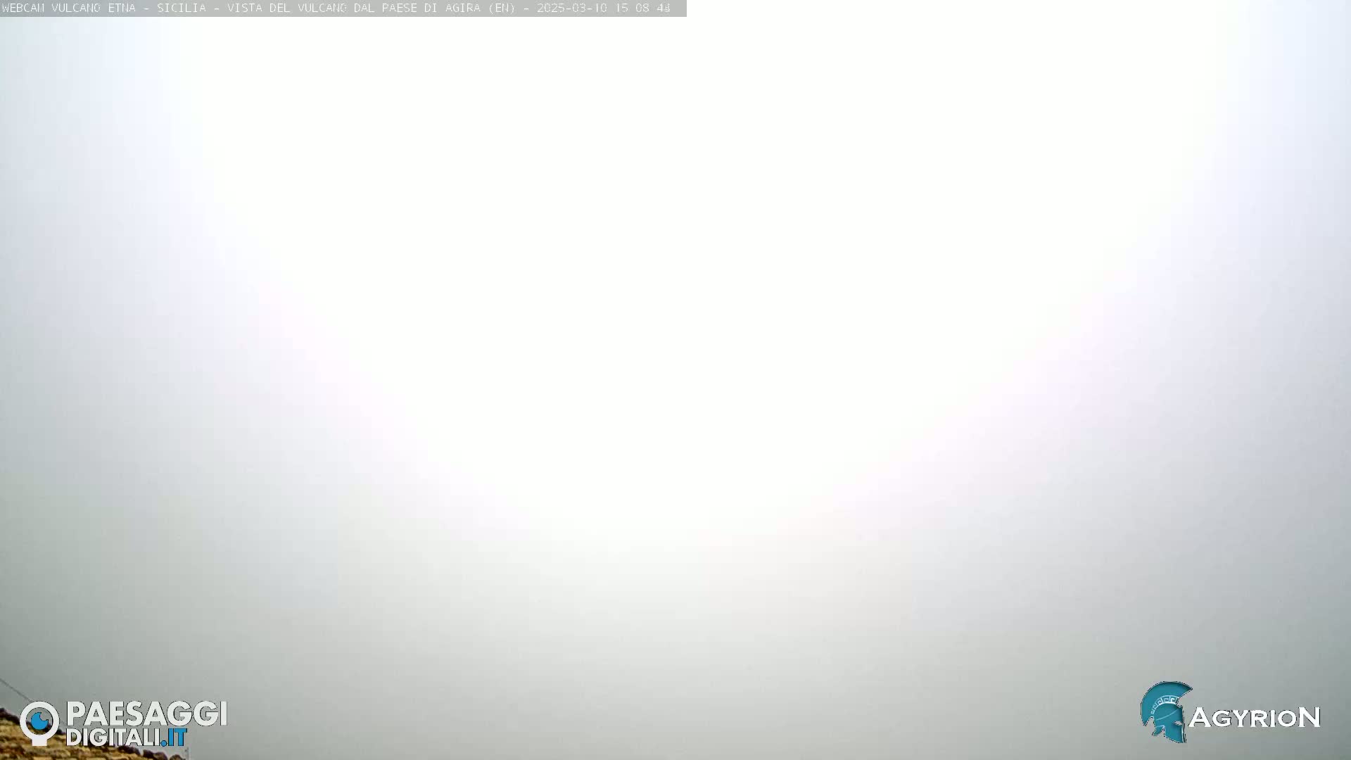 A thick, white fog obscures the view of an outdoor scene.