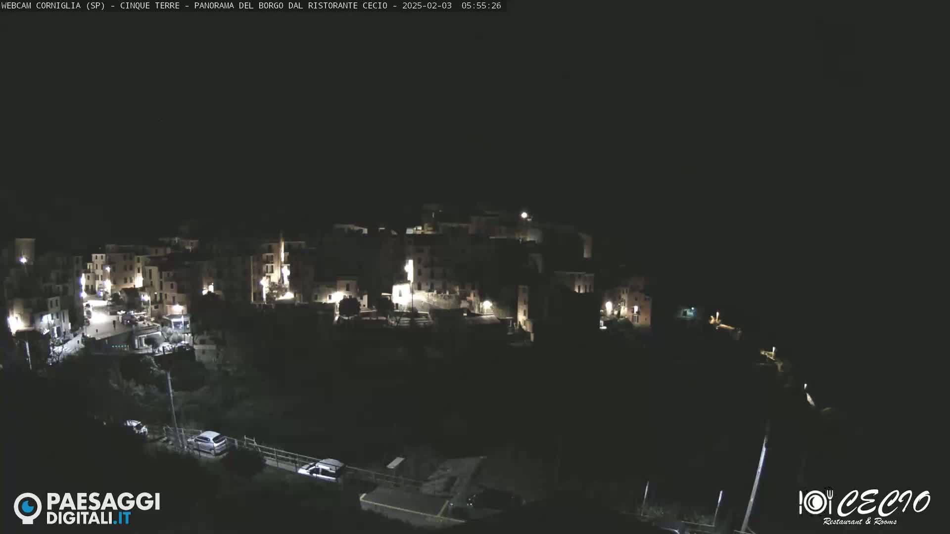 A small, dark town is illuminated by scattered lights at night.