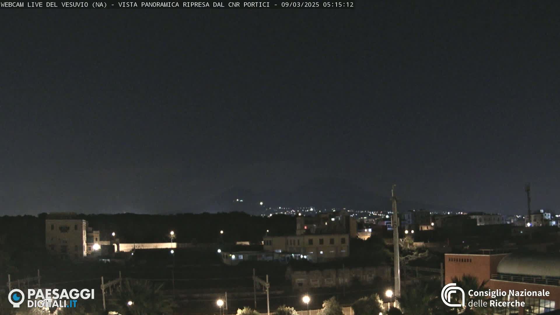 A nighttime view of a city with low-level lighting under a dark, clear sky.