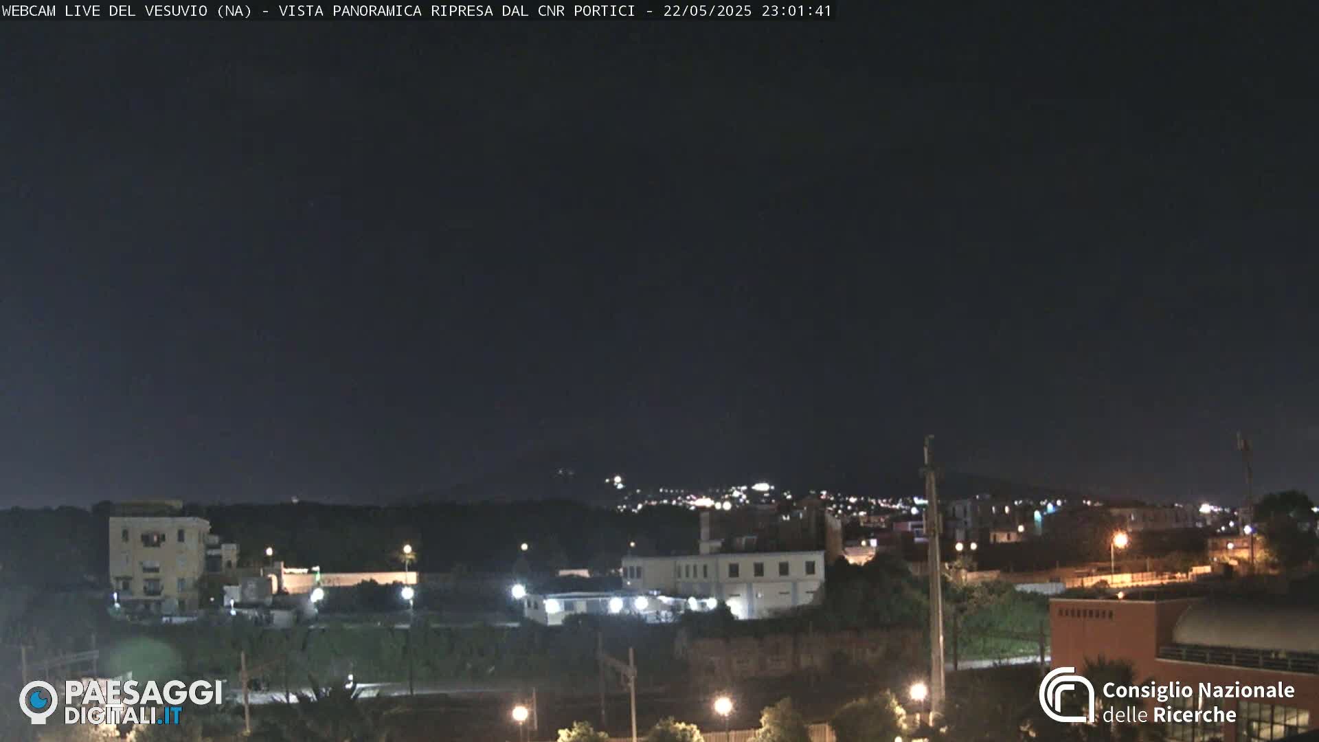 A nighttime, long shot of a town with low-level lighting under a clear, dark sky.