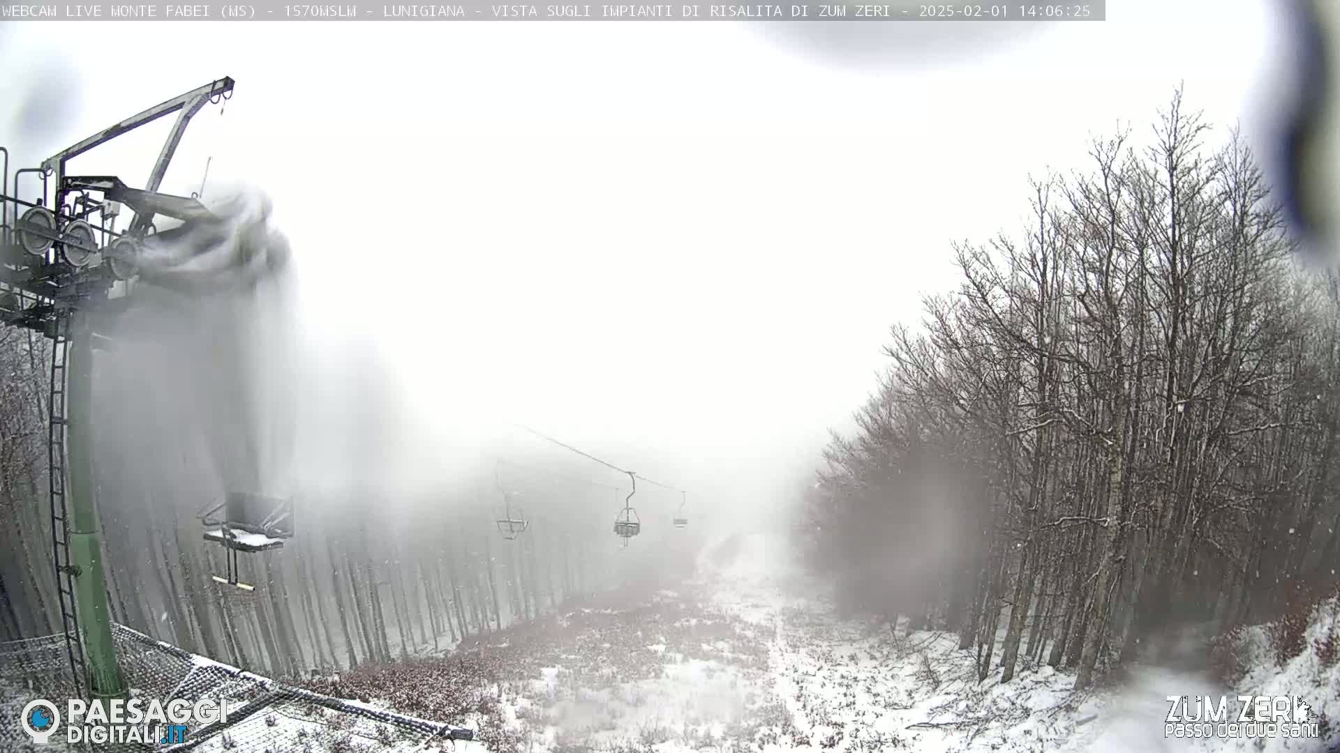 A snow-covered ski lift operates through a snowy forest in foggy conditions.