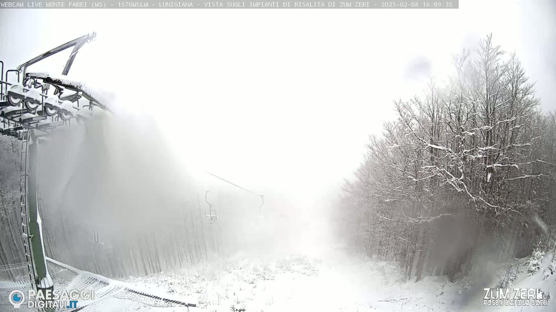 A snow-covered ski lift and surrounding snowy landscape are obscured by heavy snowfall.