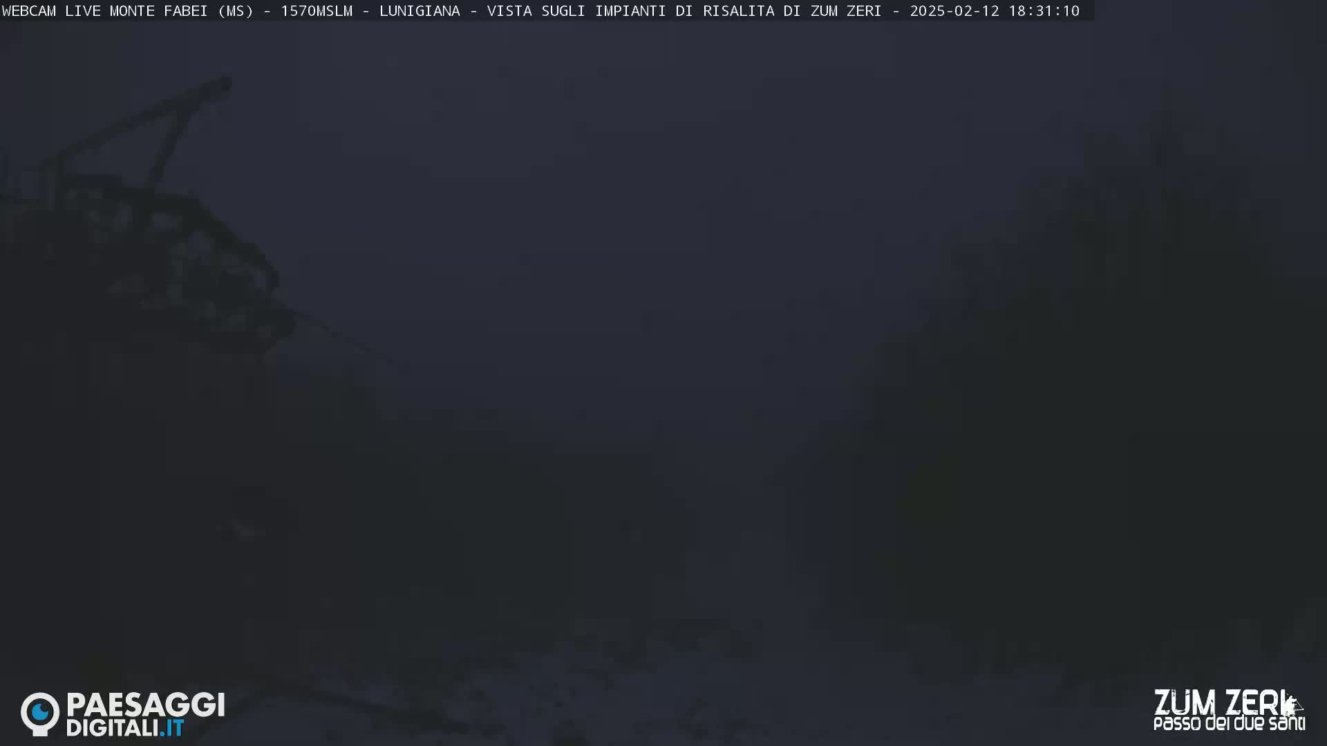 A dark, blurry image shows a partially visible structure and indistinct surroundings under a dusky sky.