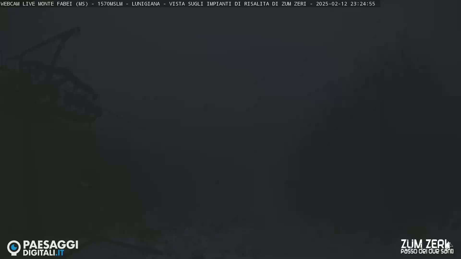 A dark, foggy scene shows a partially visible structure, possibly a lift or cable car, against a very dark background.