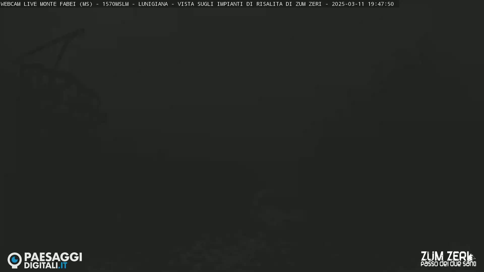 A dark, nighttime image shows a mostly obscured view of a landscape, possibly mountainous, under dark conditions.