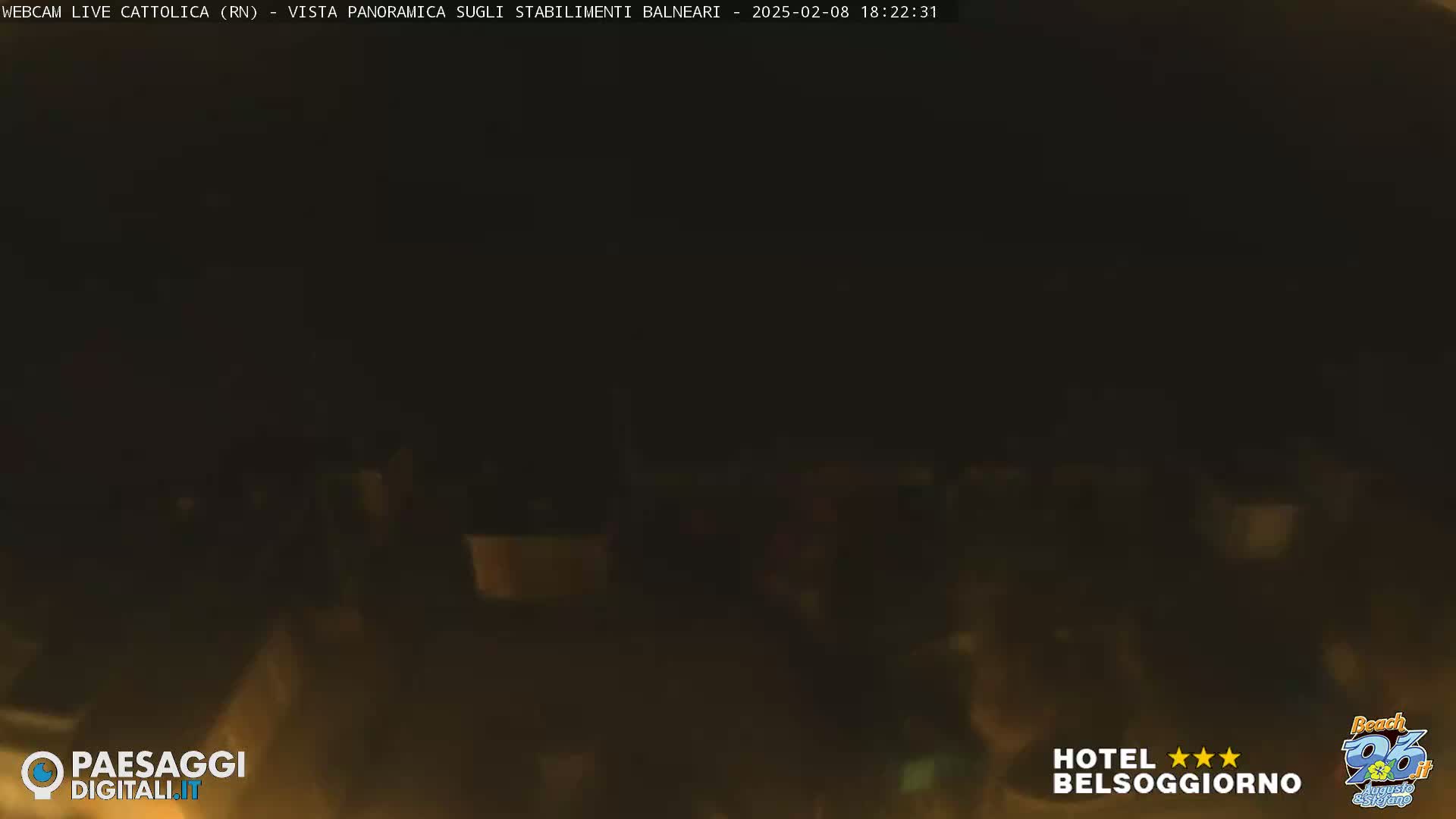 A dark, nighttime scene shows a blurry, indistinct view of what appears to be an outdoor area with faintly visible structures.