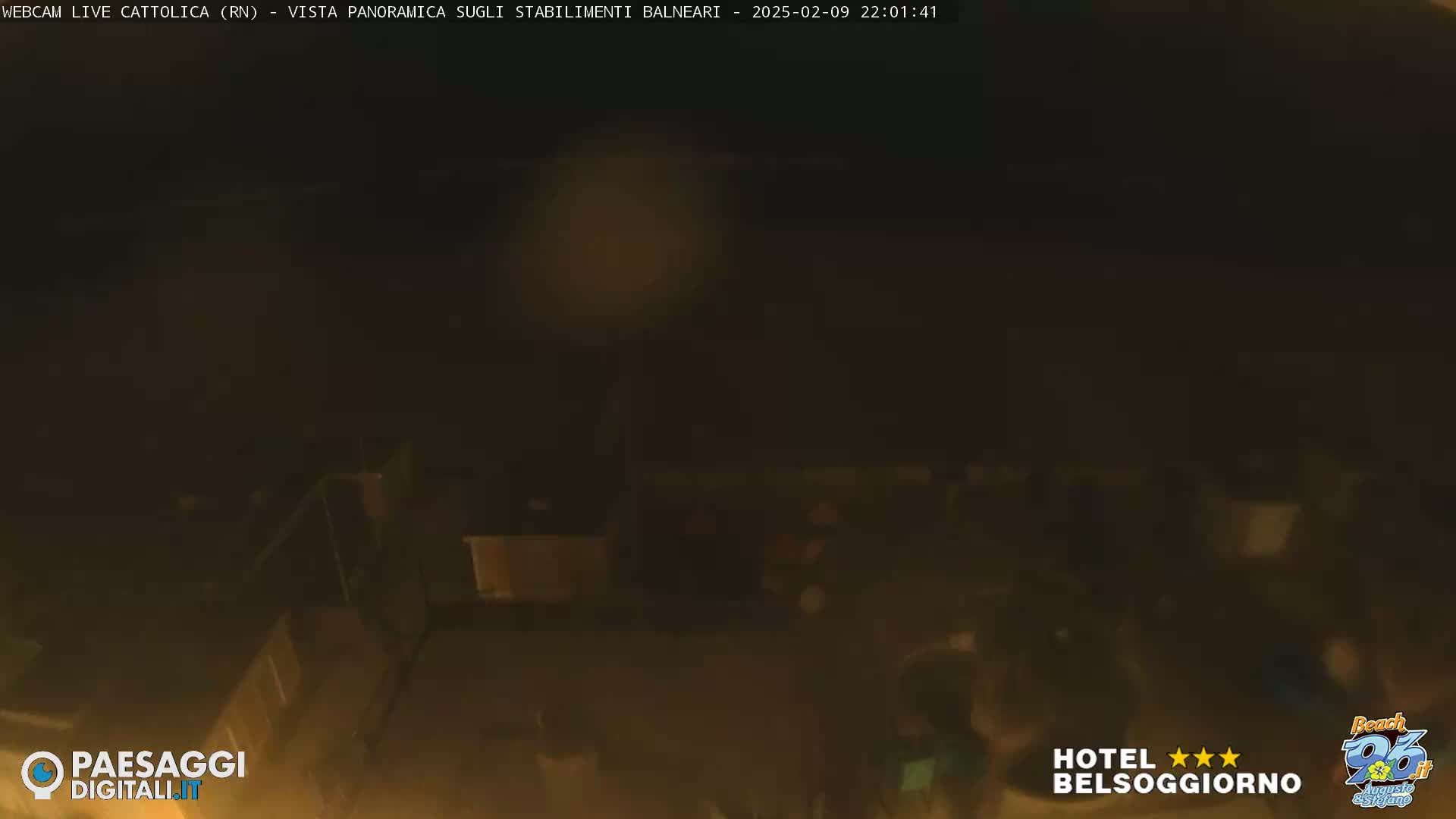 A nighttime, low-light view of a beach area with indistinct structures and objects.