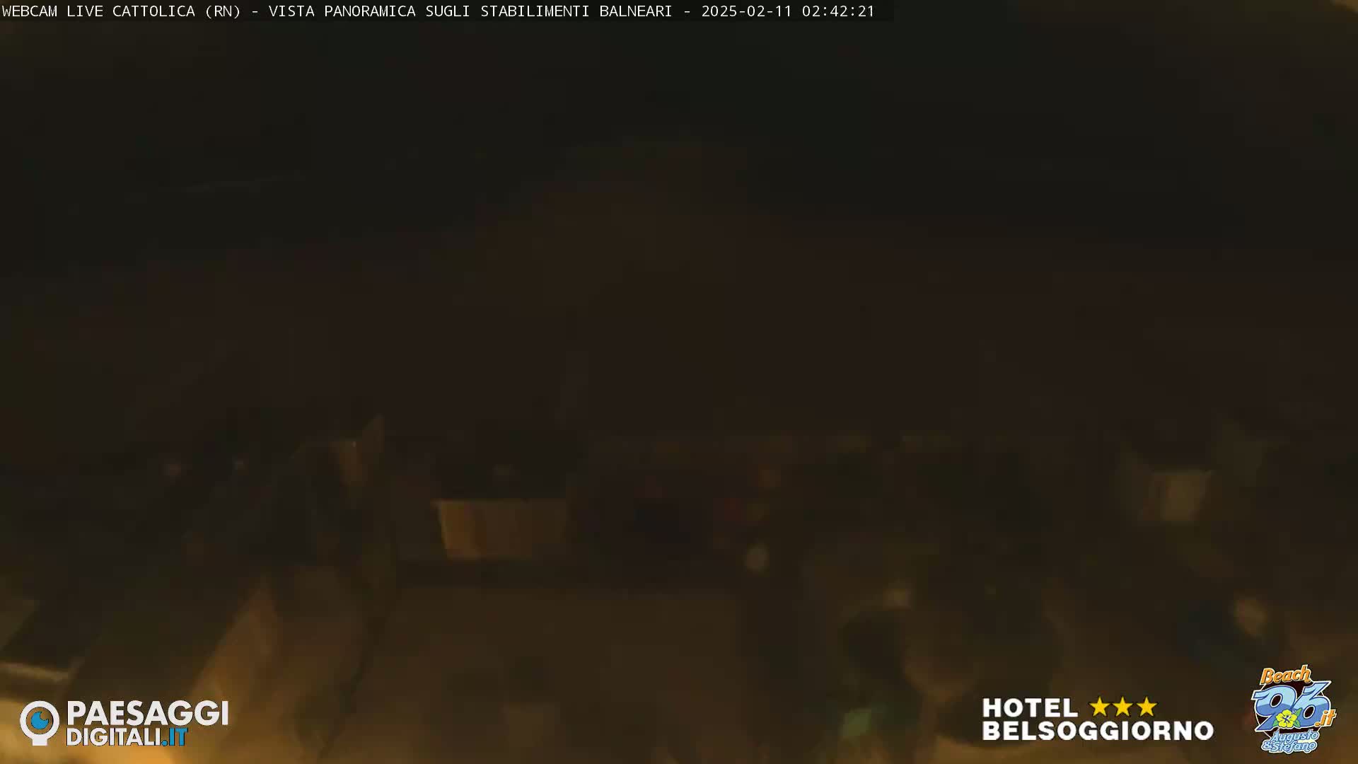 A nighttime, low-light view shows a dimly lit area with indistinct figures.