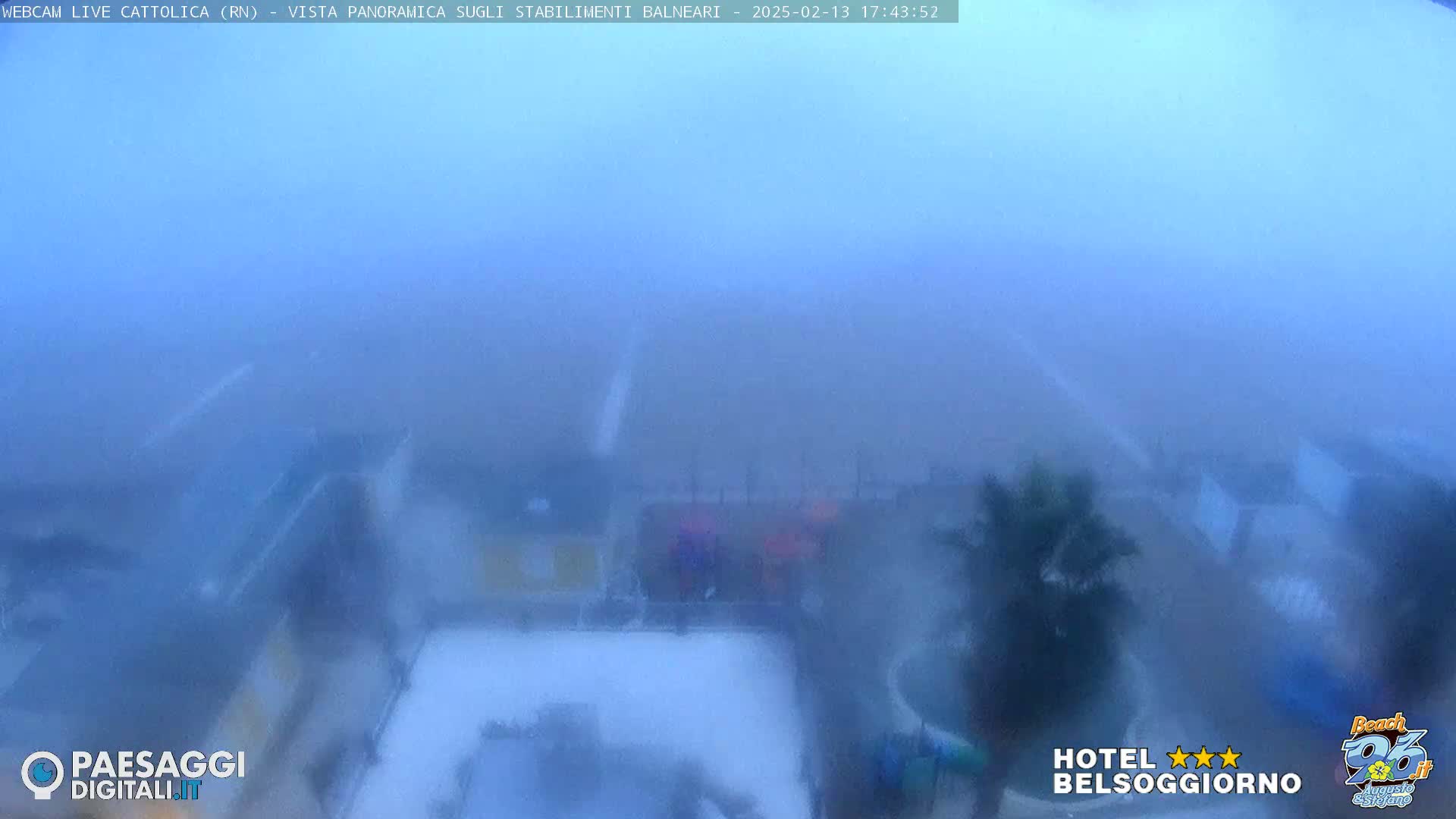 A hazy, foggy view of beachside buildings and vegetation is seen from a distance.