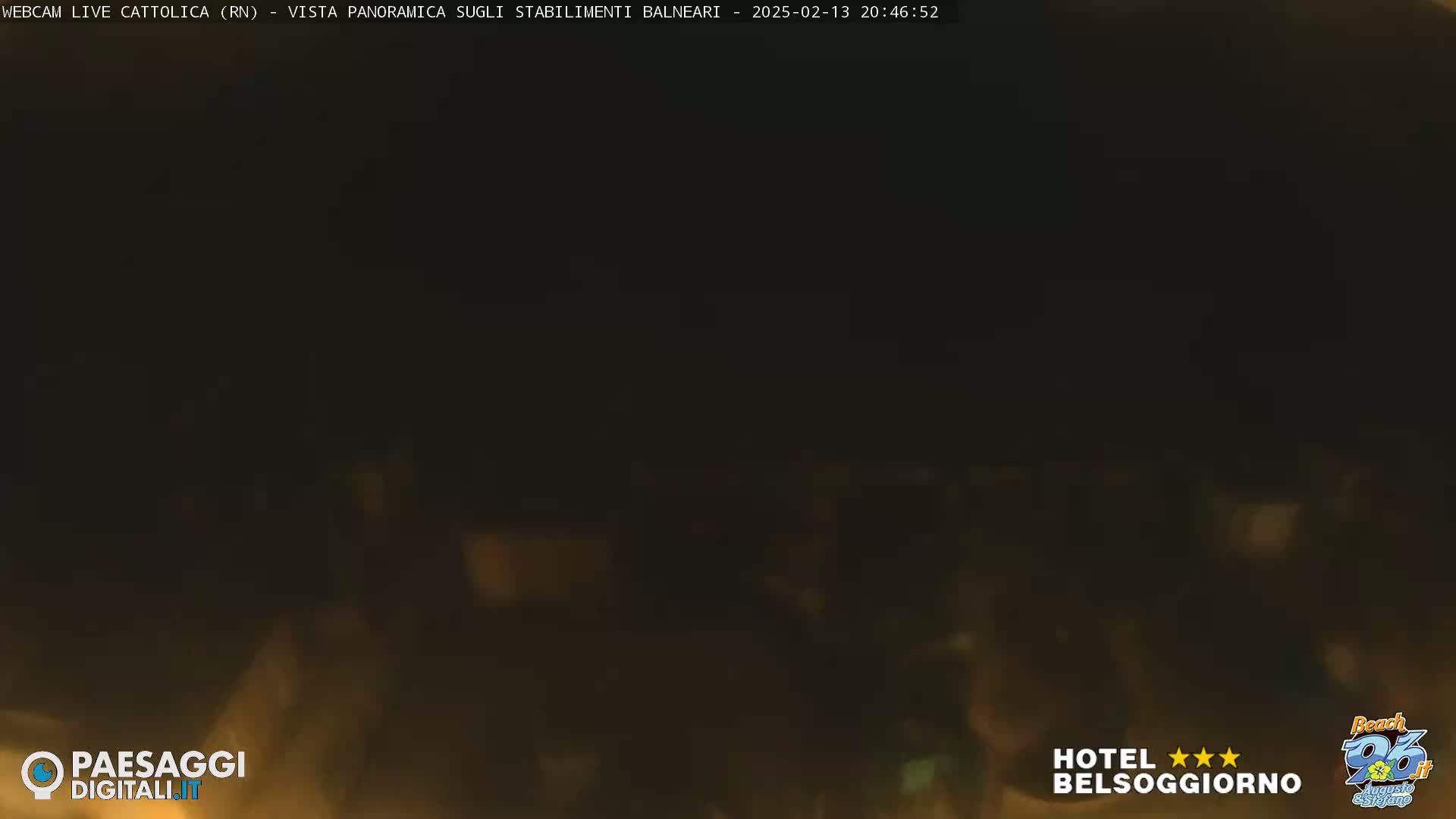A very dark, blurry nighttime image of a beach area with muted, indistinct lights.