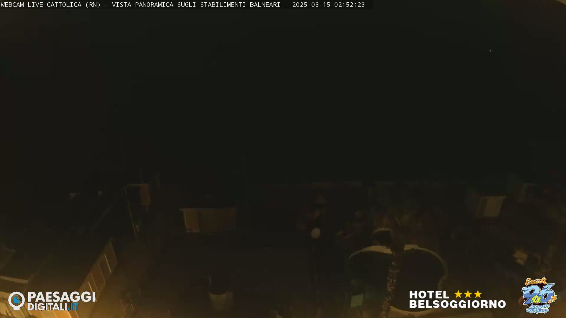 A dark nighttime scene shows a few indistinct figures near buildings and what appears to be a pool.