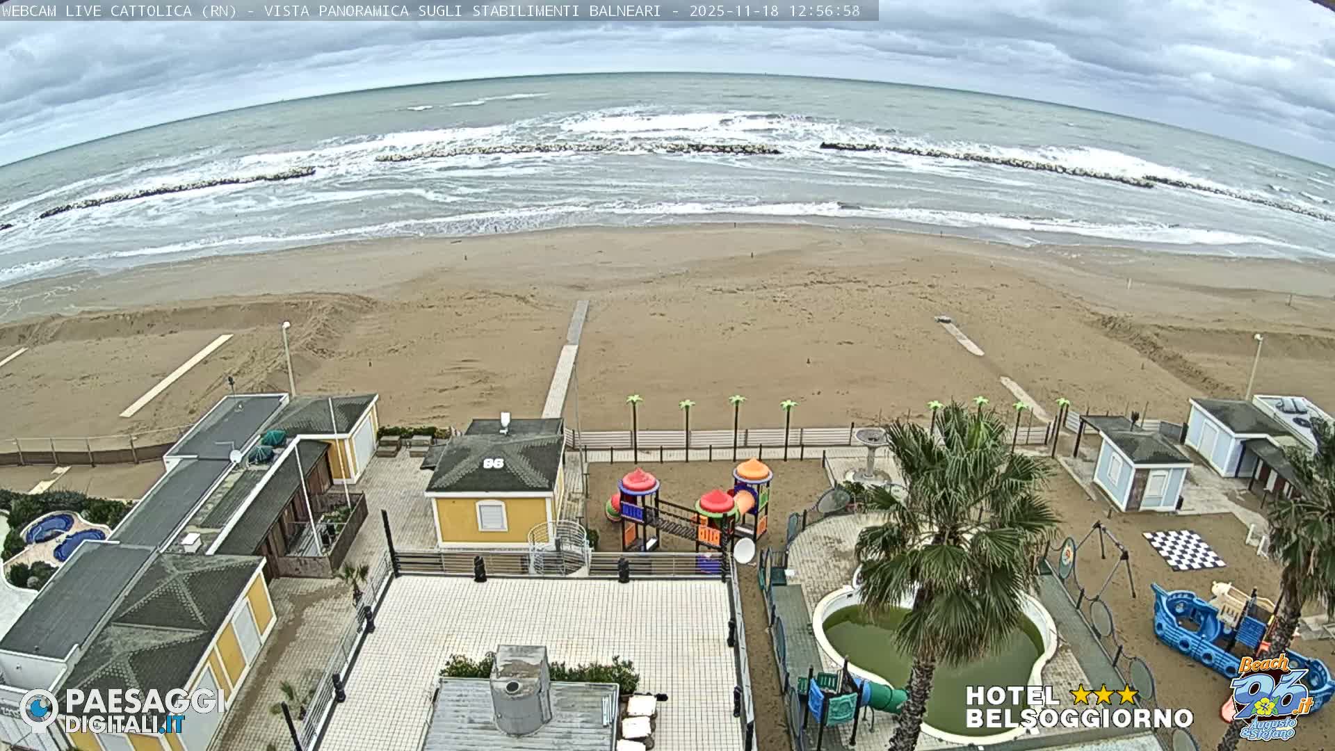 The image displays a dark outdoor scene at night, with faint outlines of buildings and some scattered vegetation visible in the lower half under clear skies.