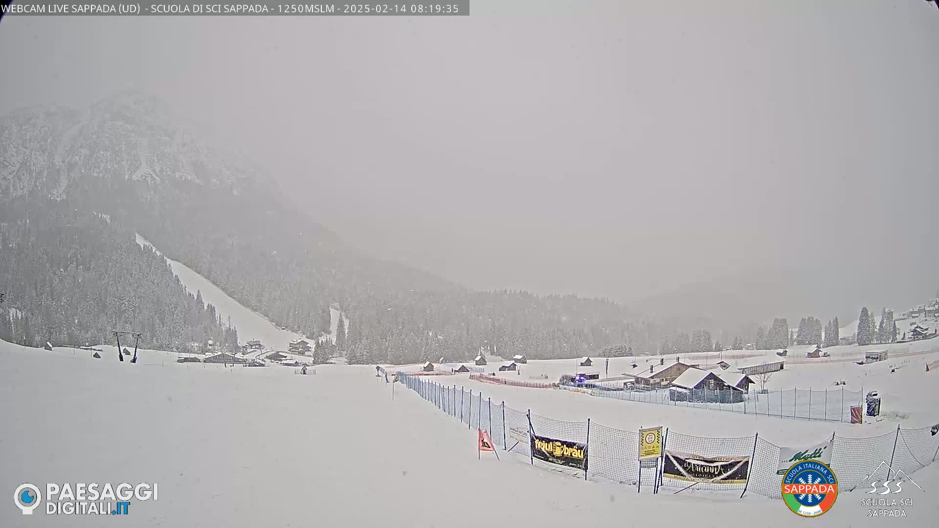 A snow-covered ski resort is visible under heavy snowfall, with a mountain in the background.
