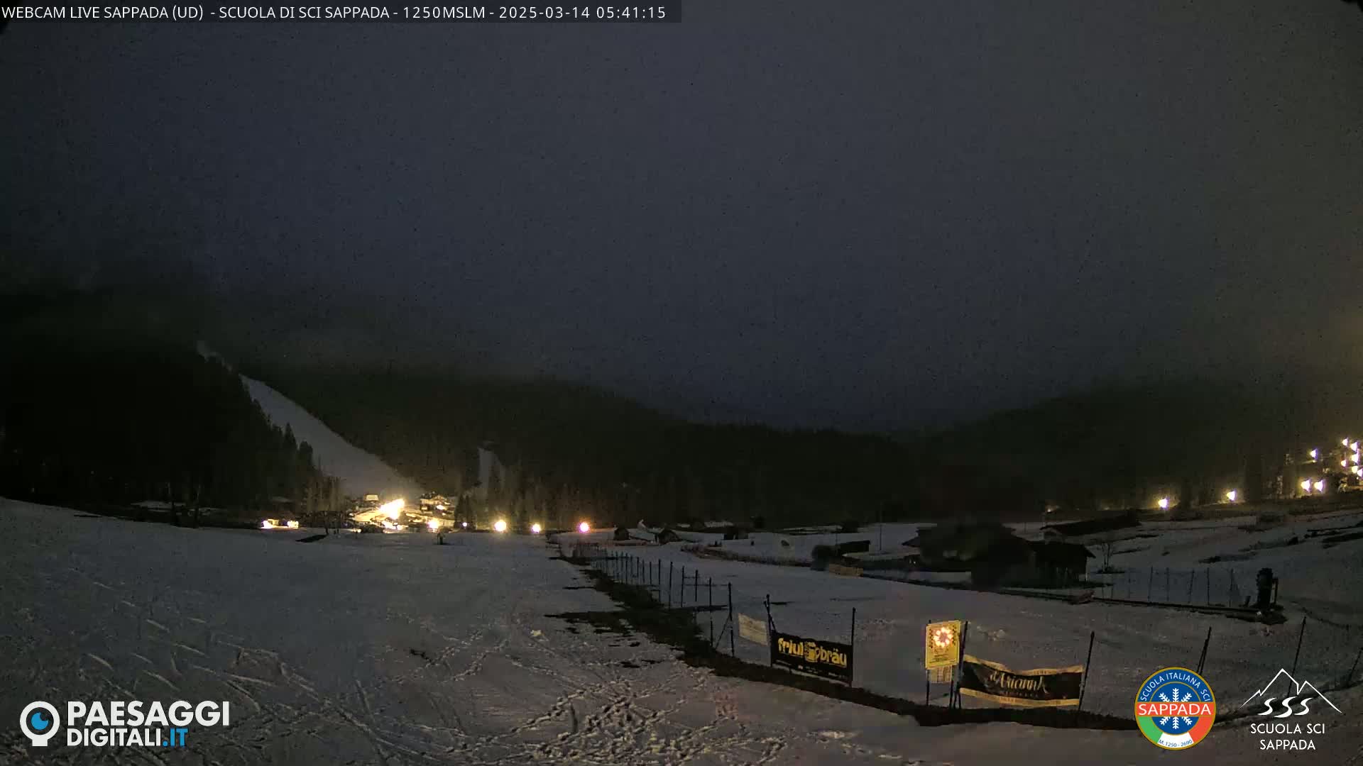 A snow-covered ski slope at night is dimly lit under a dark, overcast sky.