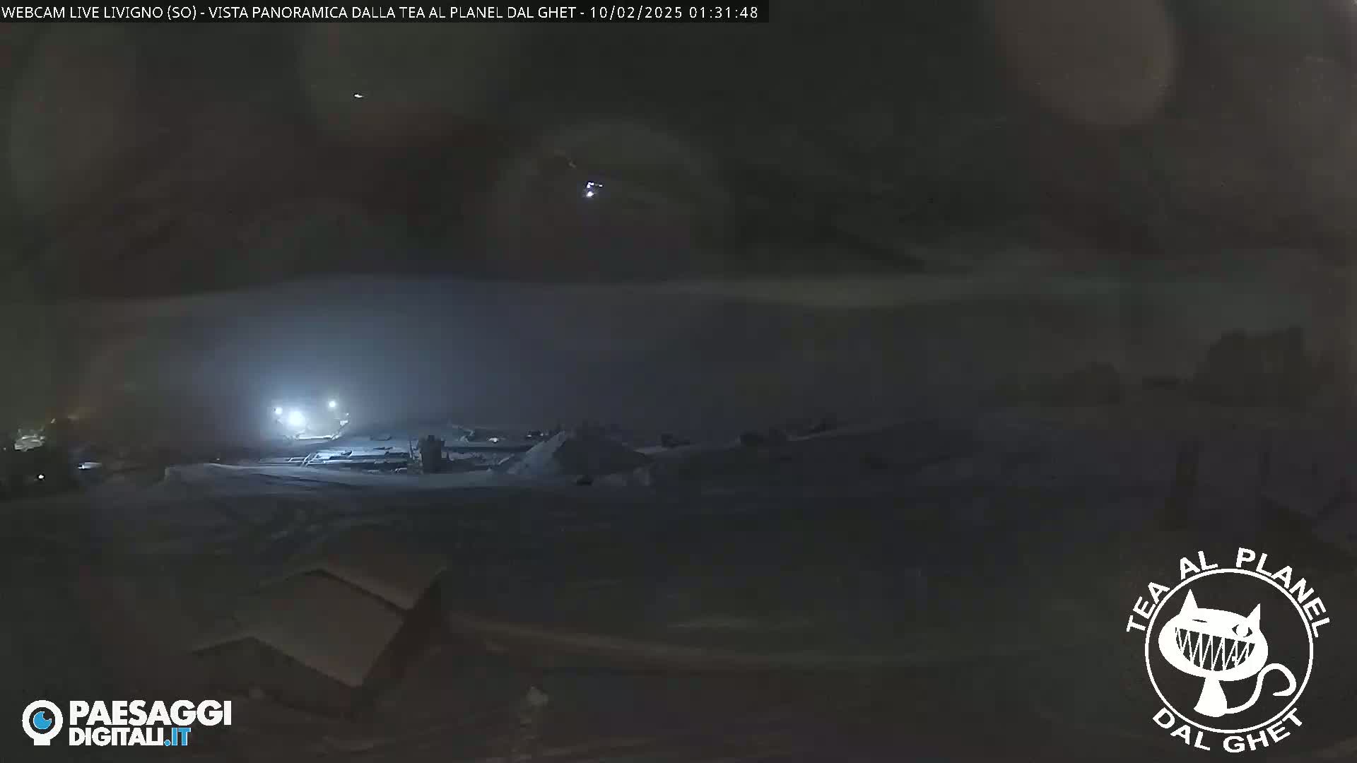A nighttime, snowy landscape is visible under a dark, cloudy sky.