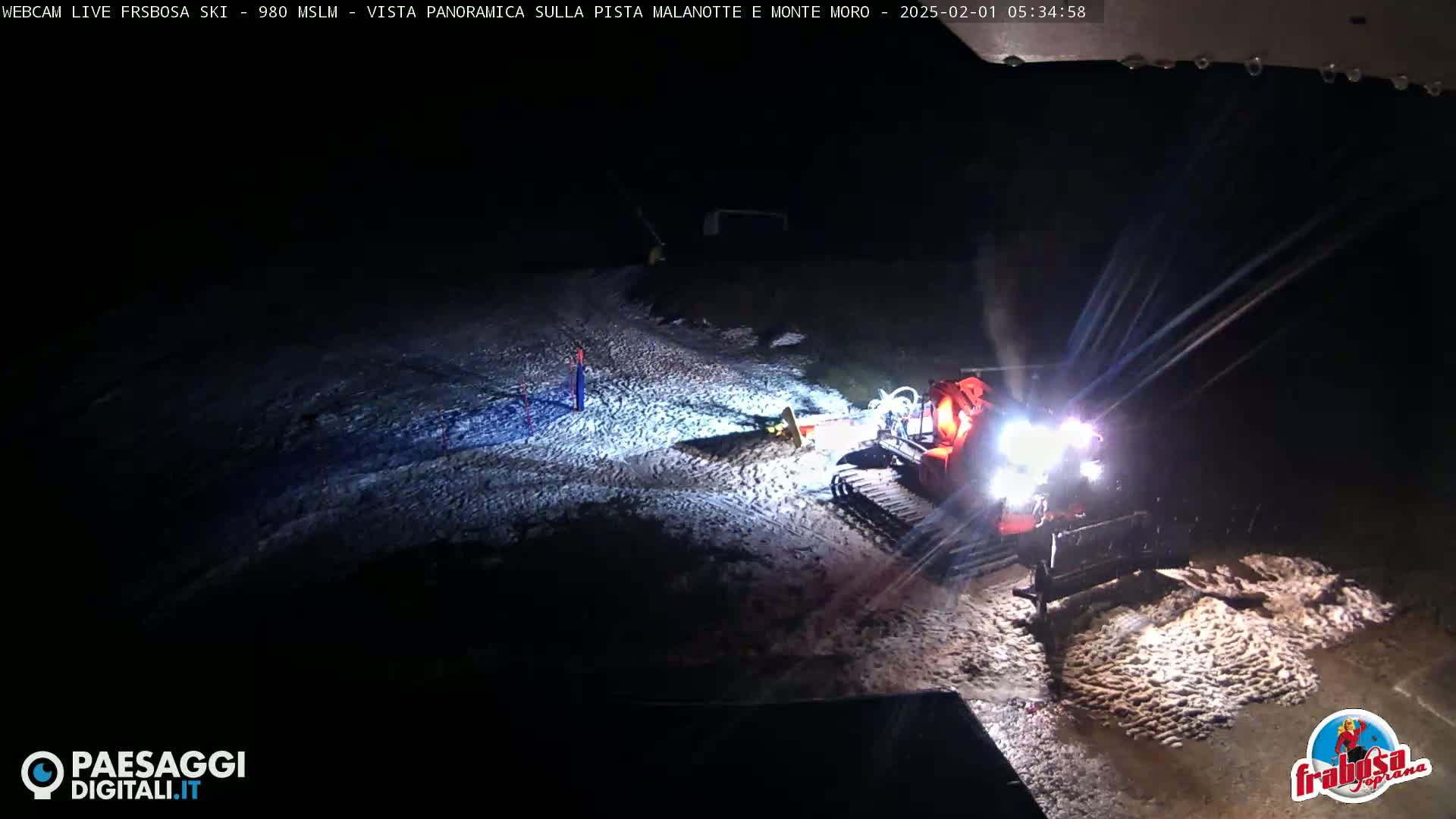 A snowcat illuminated by its headlights grooms a snow-covered ski slope at night.